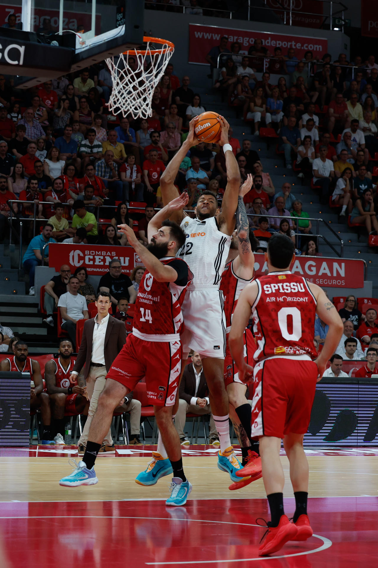 ZARAGOZA, 30/05/2025.- El pivot caboverdiano del Real Madrid, Edy Tavares (c), captura un rebote ante el jugador montenegrino de Casademont Zaragoza, Bojan Dubljevic, durante el encuentro de la Liga Endesa que disputan hoy viernes Casademont Zaragoza y Real Madrid en el pabellón Príncipe Felipe de Zaragoza. EFE / Javier Cebollada.