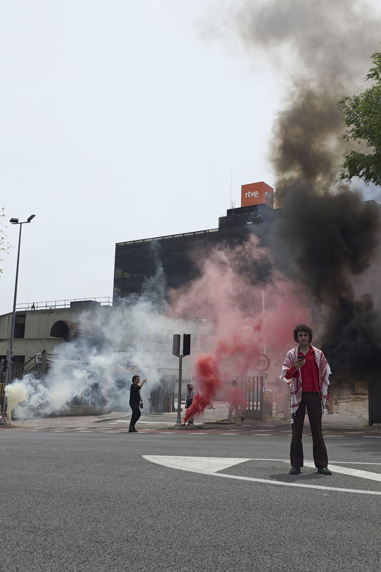 Miembros de la Acampada por Palestina de Madrid se han concentrado este sábado ante la sede de RTVE, en la calle Alcalde Sáinz de Baranda, para denunciar "el blanqueamiento mediante la música del genocidio israelí en Palestina" y para apoyar a trabajadores del ente público que "pueden ser censurados por señalar los crímenes de Israel". La protesta, que ha tenido lugar sobre las 15:00 horas, se desarrolló "de forma pacífica e incluyó el encendido de cuatro botes de humo" y la lectura de un comunicado de rechazo a la participación Israel en Eurovisión y "en apoyo de los locutores de TVE que durante la retransmisión de la semifinal hicieron comentarios sobre los muertos" causados por la ofensiva militar de Israel en Gaza. EFE/Acampada por Palestina de Madrid -SOLO USO EDITORIAL/SOLO DISPONIBLE PARA ILUSTRAR LA NOTICIA QUE ACOMPAÑA (CRÉDITO OBLIGATORIO)-