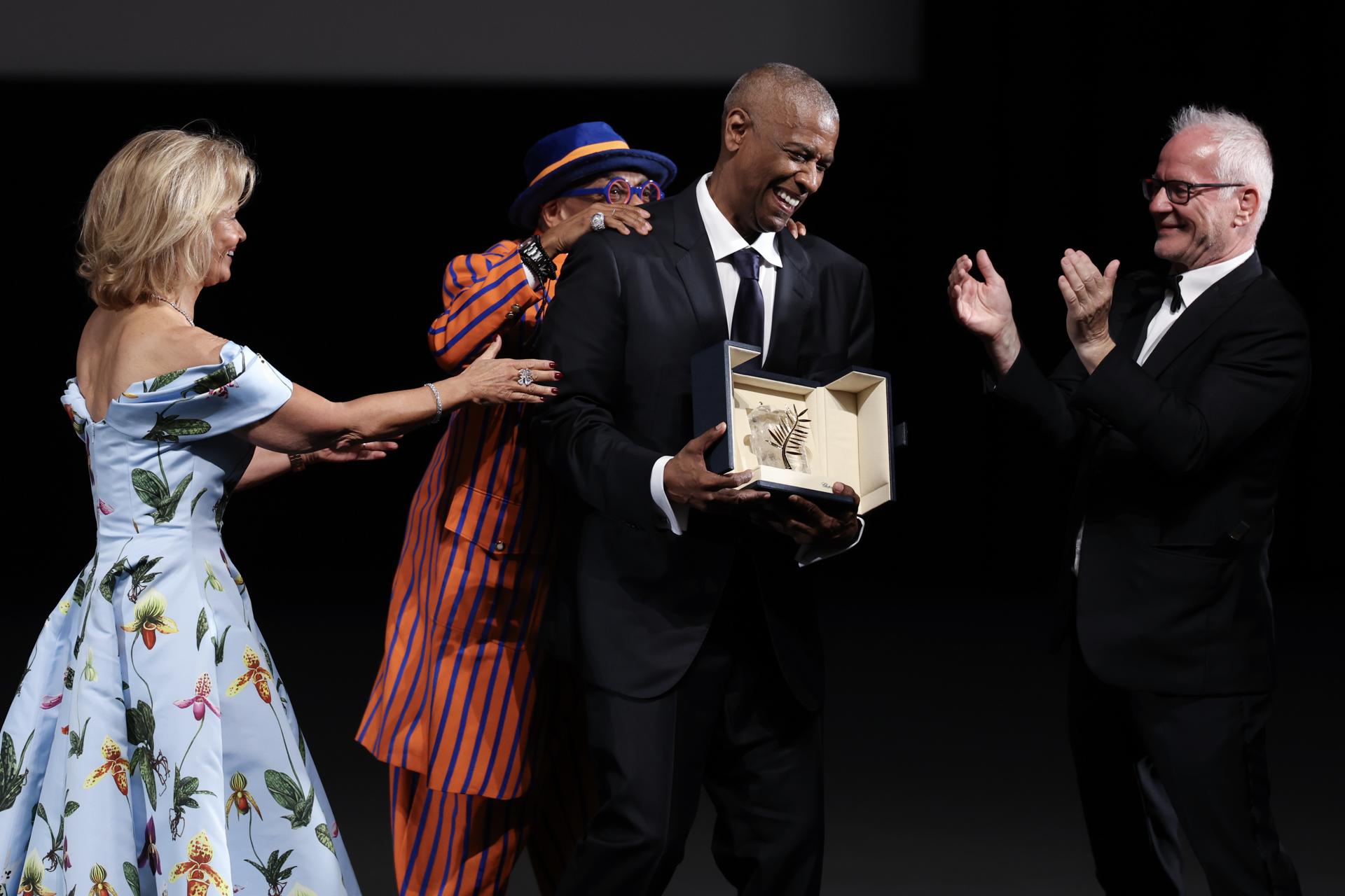 El actor estadounidense Denzel Washington (C) reacciona junto al delegado general del Festival de Cine de Cannes, Thierry Fremaux (D) y la presidenta del Festival de Cine de Cannes, Iris Knobloch, cuando recibe la Palma de Oro Honorífica del director y productor ejecutivo estadounidense Spike Lee (detrás) antes de la proyección de la película "Highest 2 Lowest" durante el 78º Festival anual de Cine de Cannes, en Cannes, Francia, el 19 de mayo de 2025. EFE/SAMEER AL-DOUMY / POOL
