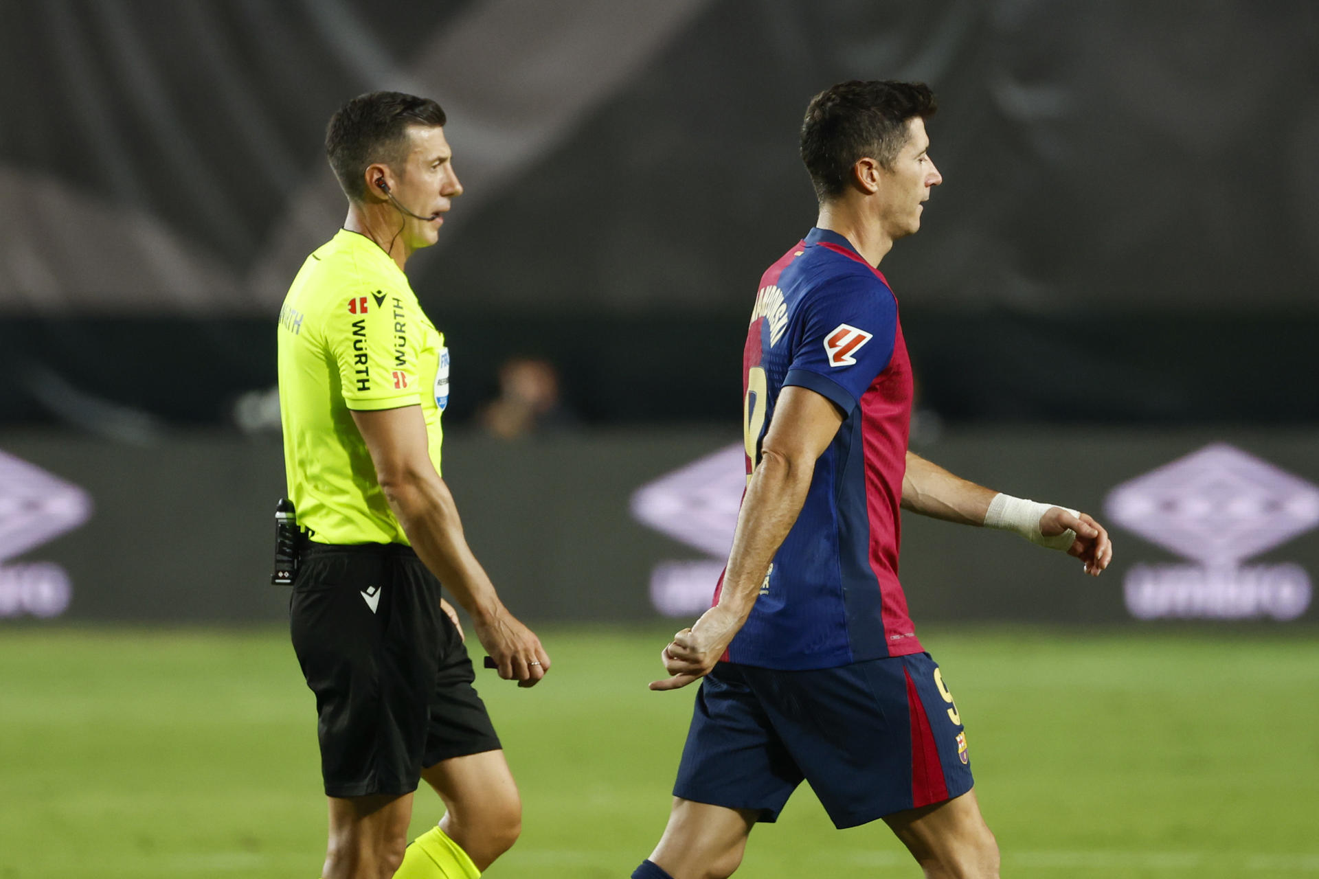 El árbitro César Soto Grado (i) tras anular el gol a Robert Lewandowski (d), del Barcelona, durante el partido de la tercera jornada de Liga contra el Rayo Vallecano. EFE/Mariscal