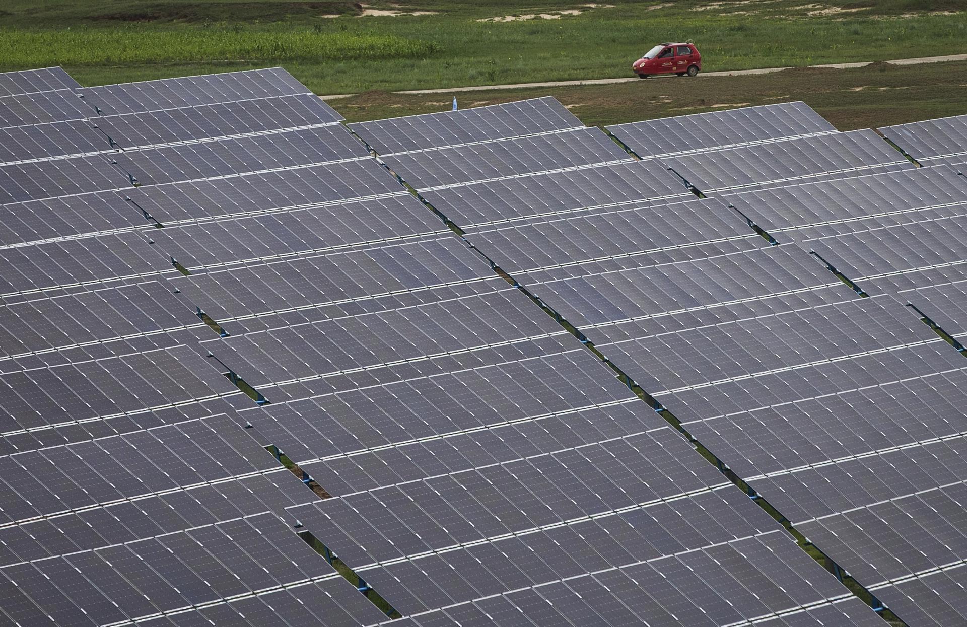 Un coche pasa junto a los paneles solares de la planta de energía solar Panda en Datong (China), en una fotografía de archivo. EFE/Roman Pilipey