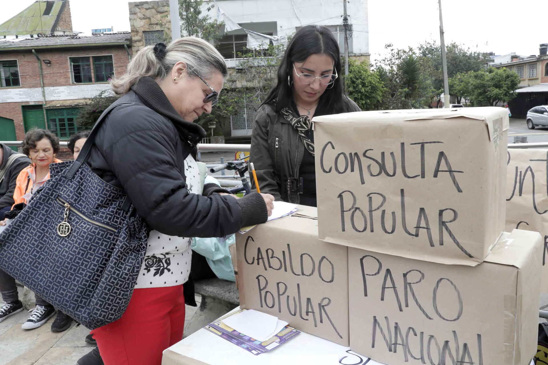 Una mujer participa en una votación simbólica durante una manifestación en apoyo al presidente de Colombia, Gustavo Petro, este domingo en la Plazoleta del Concejo, en Bogotá (Colombia). EFE/ Carlos Ortega
