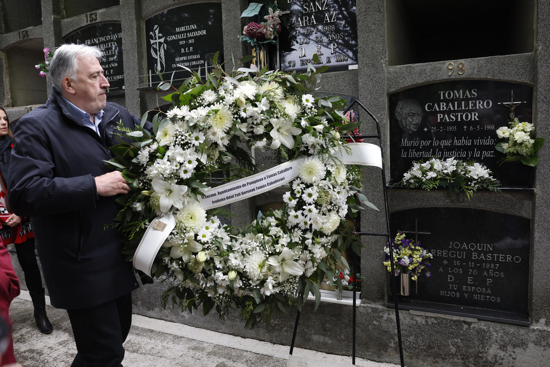 El Ayuntamiento de Pamplona, con el alcalde Joseba Asirón a la cabeza y acompañado entre otros por la concejal de UPN, Cristina Ibarrola durante el homenaje este martes al concejal de UPN Tomás Caballero asesinado el 6 de mayo de 1998 por la banda terrorista ETA con la celebración en el cementerio de San José de un responso por parte del párroco de San Lorenzo, Javier Leoz, y la colocación de una corona de flores. EFE/ Jesús Diges