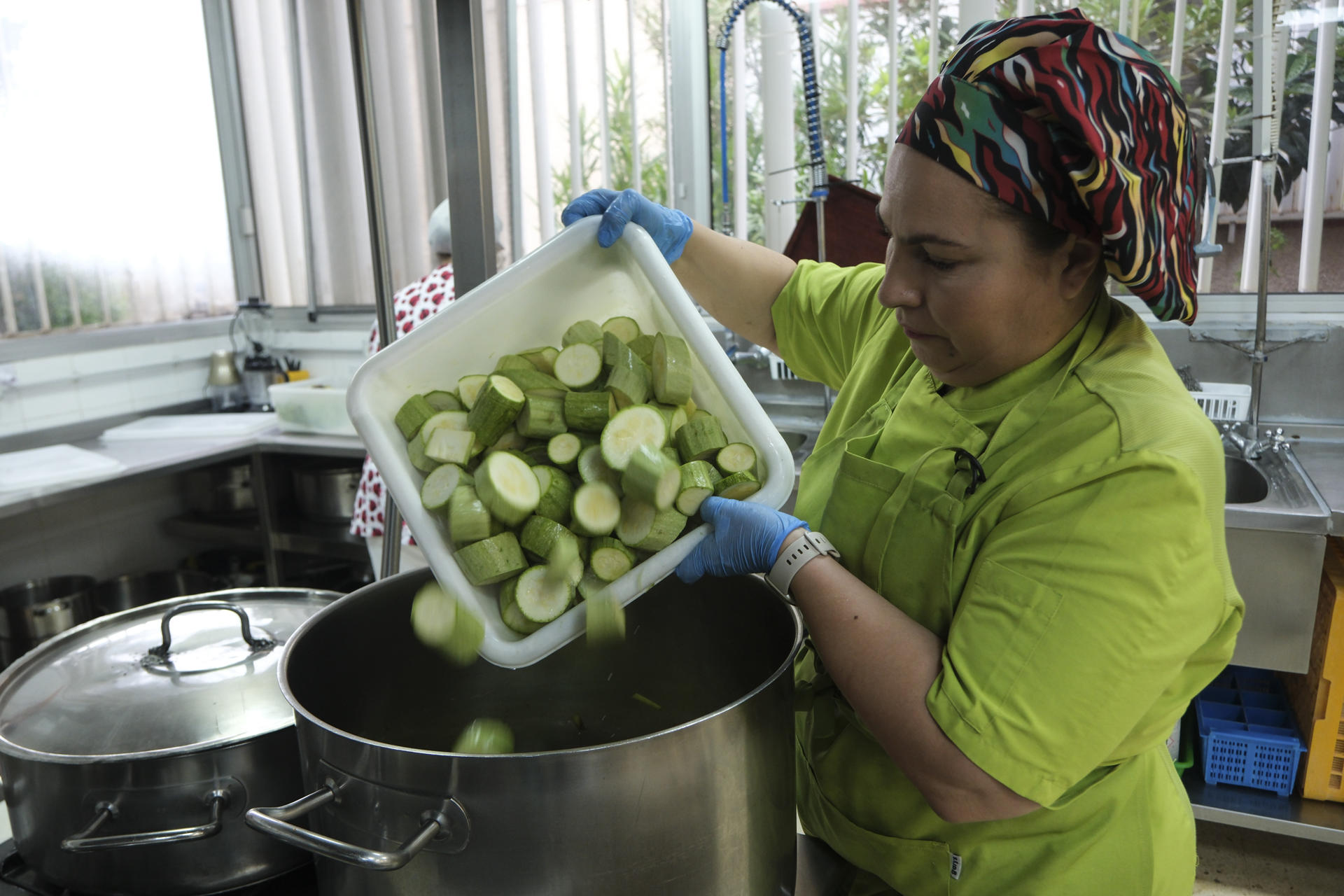 Los agricultores, los educadores, los cocineros, los alumnos y las familias lo tienen claro: el programa que lleva frutas y verduras ecológicas y de temporada desde las huertas hasta los centros educativos de Canarias es todo un éxito. Se llama Ecocomedores e inspira el decreto que el Consejo de Ministros ha aprobado para el resto de España. En la imagen, trabajadores de la cocina del colegio Las Mercedes, en La Laguna (Tenerife) preparan el almuerzo para los alumnos. EFE/Alberto Valdés
