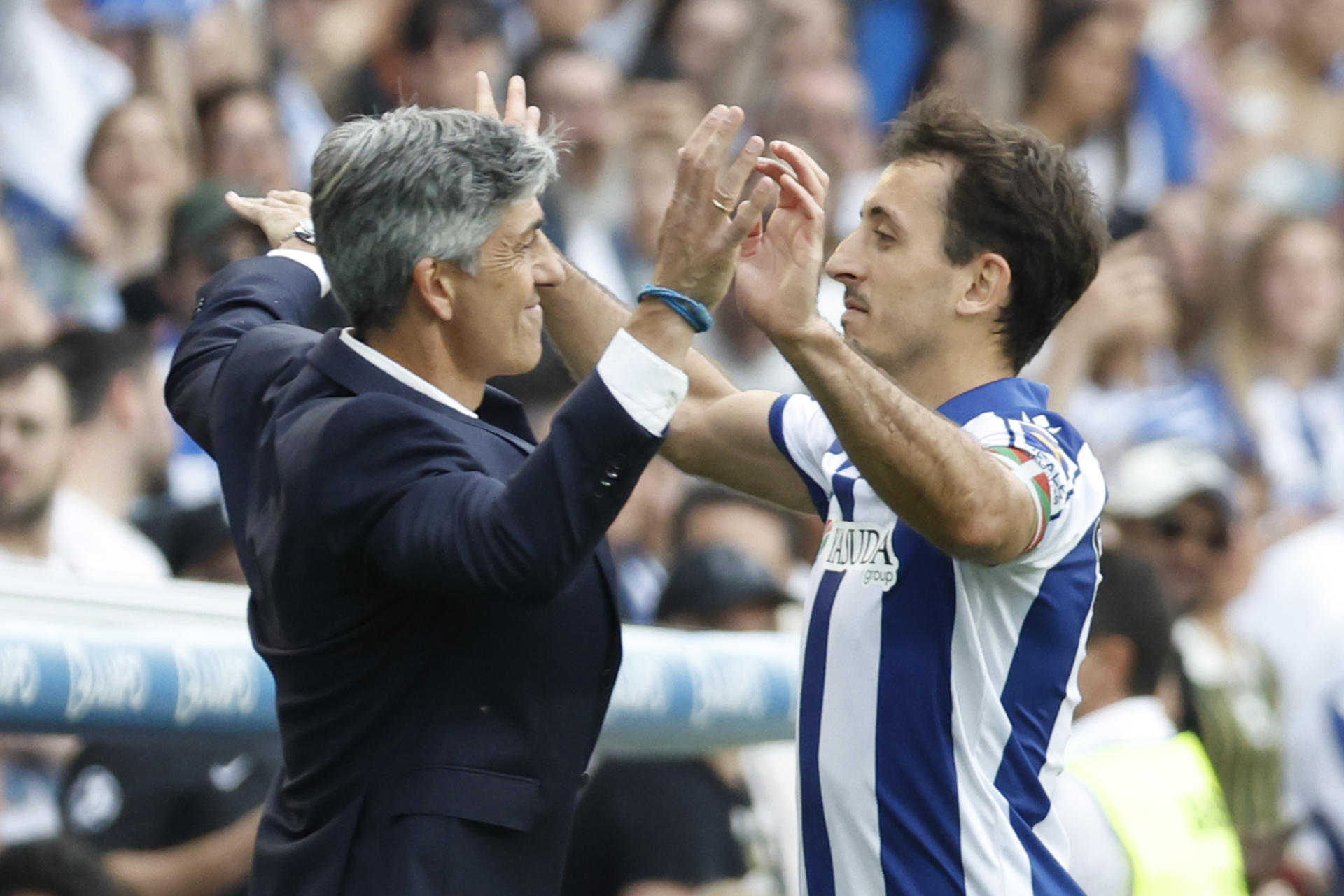 El delantero de la Real Sociedad Mikel Oyarzábal (d) celebra el segundo gol de su equipo con el entrenador Imanol Alguacil durante el partido de LaLiga entre la Real Sociedad y el Girona, este domingo en el estadio Reale Arena. EFE/ Javier Etxezarreta