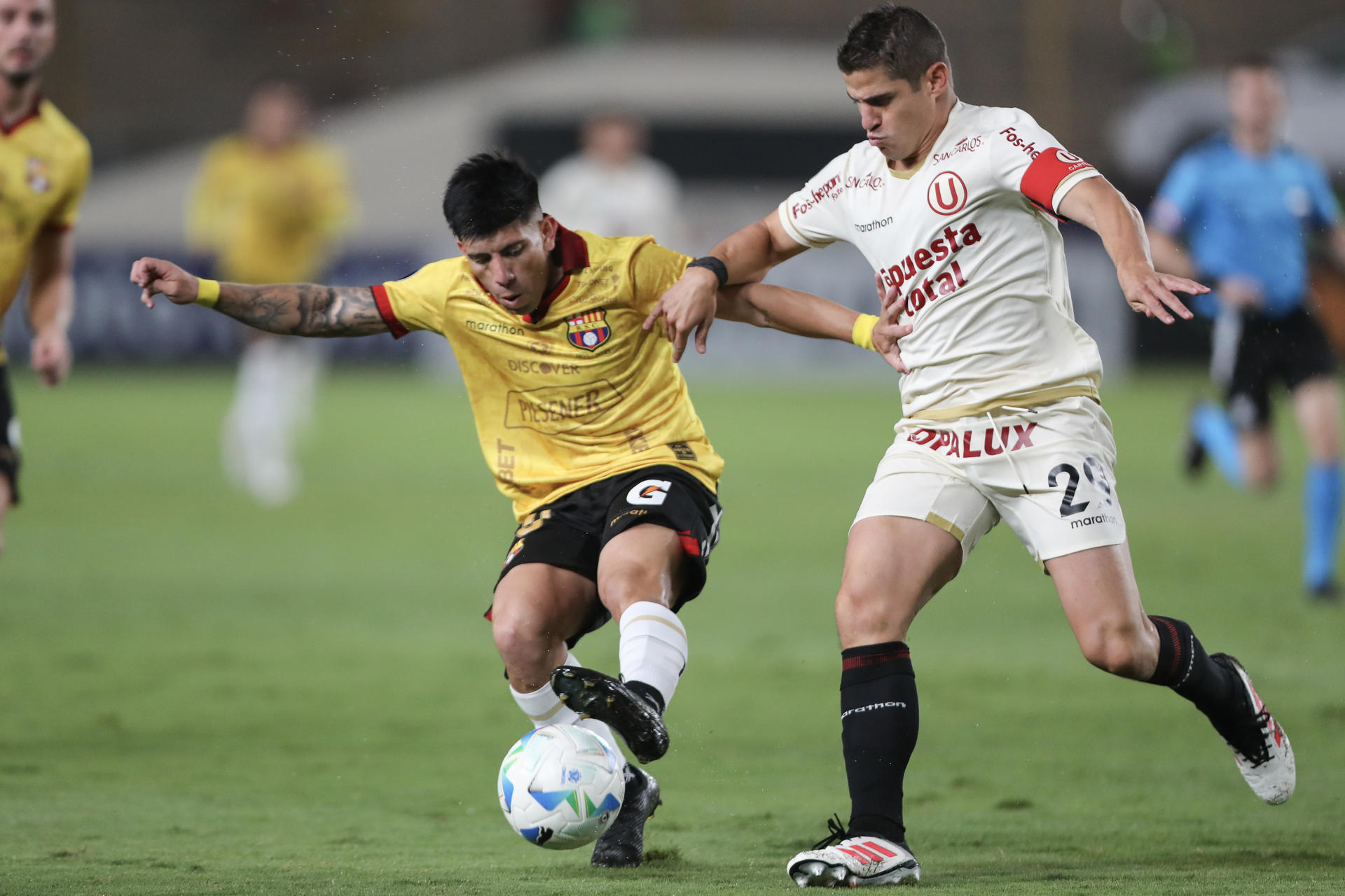 Aldo Corzo (d), de Universitario, disputa un balón con Braian Oyola, de Barcelona, en un partido de la fase de grupos de la Copa Libertadores entre Universitario y Barcelona SC en el estadio Monumental U Marathon en Lima (Perú). EFE/ Paolo Aguilar