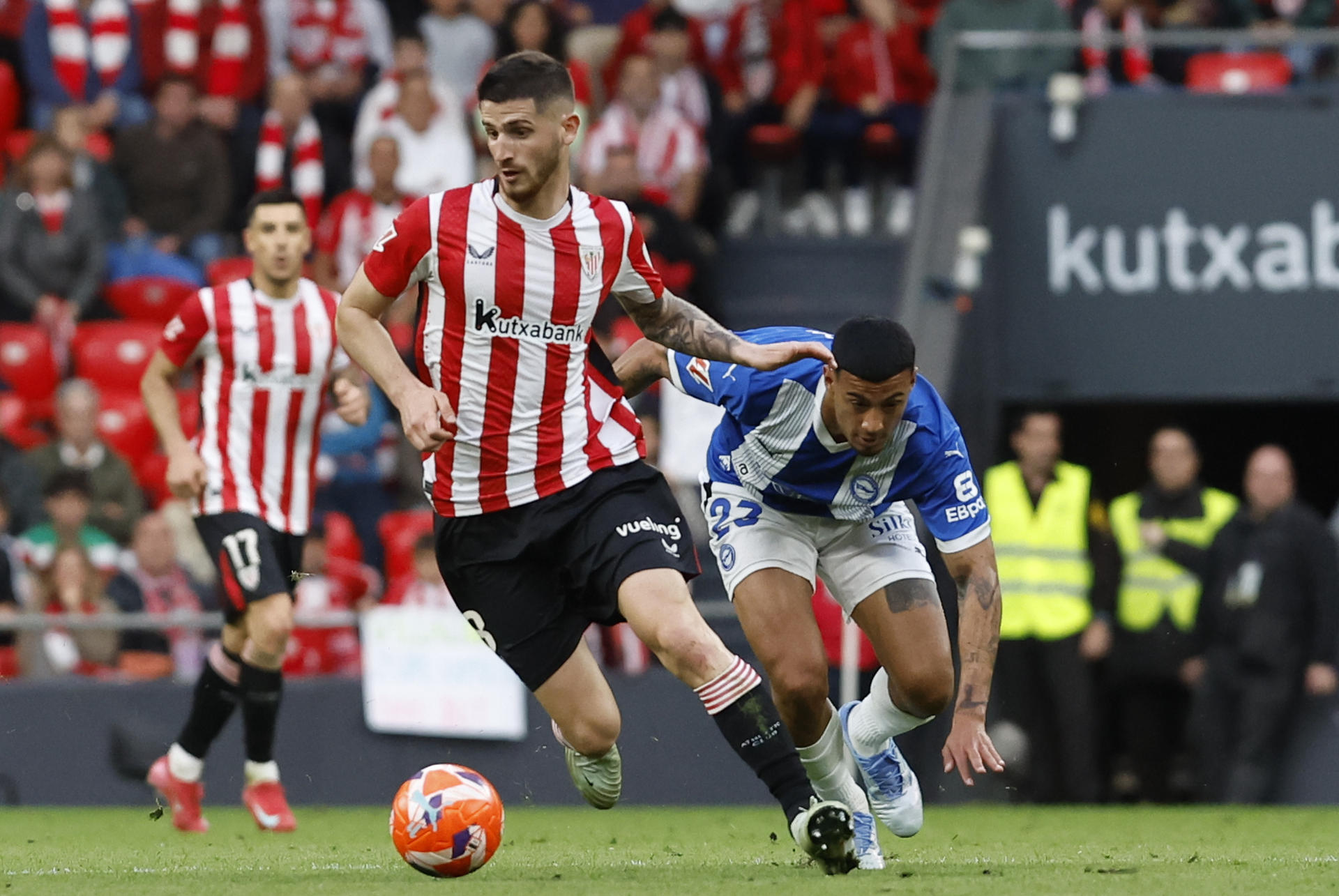 El centrocampista del Athletic Club, Oihan Sancet (i), con el balón ante el centrocampista uruguayo del Alavés, Carlos Benavídez, durante el encuentro correspondiente a la jornada 35 de Laliga EA Sports que disputaron Athletic Club y Alavés en el estadio de San Mamés, en Bilbao. EFE / Miguel Toña.