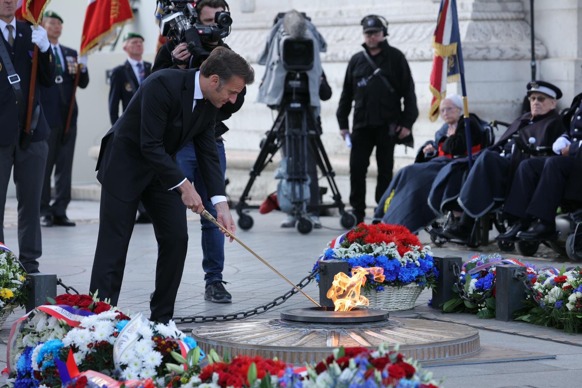 El presidente de Francia, Emmanuel Macron, vuelve a encender la llama de la Tumba del Soldado Desconocido durante una ceremonia en el Arco del Triunfo por el 80 aniversario del Día de la Victoria en Europa, EFE/EPA/THOMAS SAMSON / POOL MAXPPP OUT