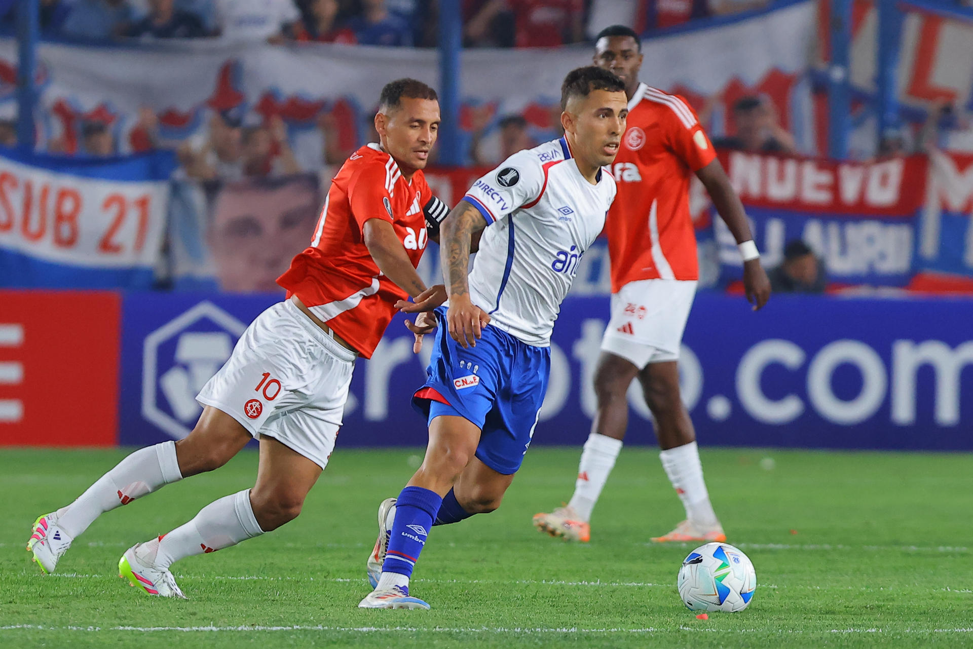 Christian Oliva (d), de Nacional, disputa un balón con Alan Patrick (i), de Internacional, durante un partido de la fase de grupos de la Copa Libertadores entre Nacional e Internacional en el estadio Gran Parque Central en Montevideo (Uruguay). EFE/ Gastón Britos