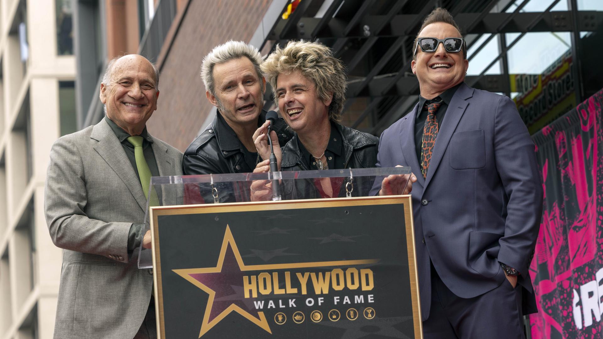 Los miembros de Green Day Billie Joe Armstrong (2-R), Mike Dirnt (2-I) y Tre Cool (R) se ríen en el escenario con Steven Nissen, presidente de la Cámara de Comercio de Hollywood (I), durante la ceremonia de entrega de estrellas en el Paseo de la Fama de Hollywood en honor a Green Day en Los Ángeles, California, EE. UU., el 1 de mayo de 2025. EFE/EPA/JILL CONNELLY