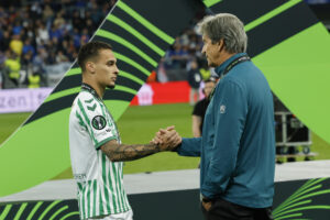 El delantero brasileño del Betis, Antony y el técnico chileno, Manuel Pellegrini, tras recibir la medalla de subcampeones a la finalización del encuentro correspondiente a la final de la Liga de Conferencia que han disputado Chelsea y Betis en el Tarczynski Arena de Breslávia. EFE / Julio Muñoz.