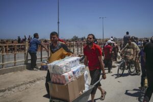 Palestinos transportan suministros de ayuda recibidos de la Gaza Humanitarian Foundation, respaldada por Estados Unidos, a través de una zona conocida como el Corredor Netzarim, en el centro de la Franja de Gaza, el 29 de mayo de 2025. EFE/HAITHAM IMAD