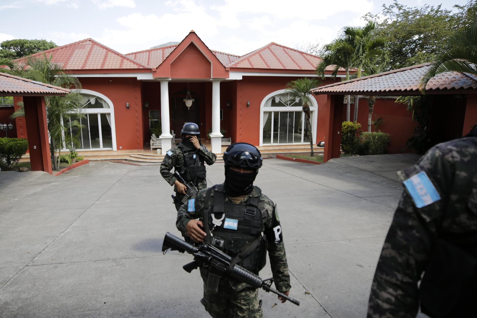 Militares hondureños acompañan a un agente de la Dirección de Lucha Contra el Narcotráfico (DLCN) en el allanamiento de la residencia del exjefe del Estado Mayor Conjunto de las Fuerzas Armadas de Honduras Romero Vásquez este sábado, en Tegucigalpa (Honduras). EFE/ Gustavo Amador