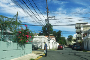 Fotografía de archivo en donde un hombre camina por una calle con tendidos eléctricos en el barrio de Santurce, en San Juan (Puerto Rico). EFE/Esther Alaejos