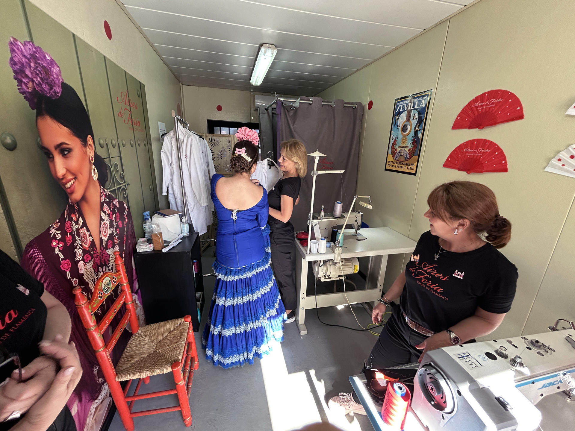Una joven vestida de flamenca llega con el traje roto para que se lo cosan las modistas de la empresa sevillana 'Aires de Feria' que junto al Ayuntamiento sevillano se ha desvelado como un servicio público de primer orden. Entre las casi 1.100 casetas de la Feria de Abril de Sevilla hay una en la que no hay bebida ni comida ni gente bailando sevillanas, sino un equipo de mujeres que, aguja en mano, arregla los desperfectos, como roturas o desgarros, en los trajes de flamenca de las miles de mujeres que pasan estos días por el Real.EFE/Fermín Cabanillas