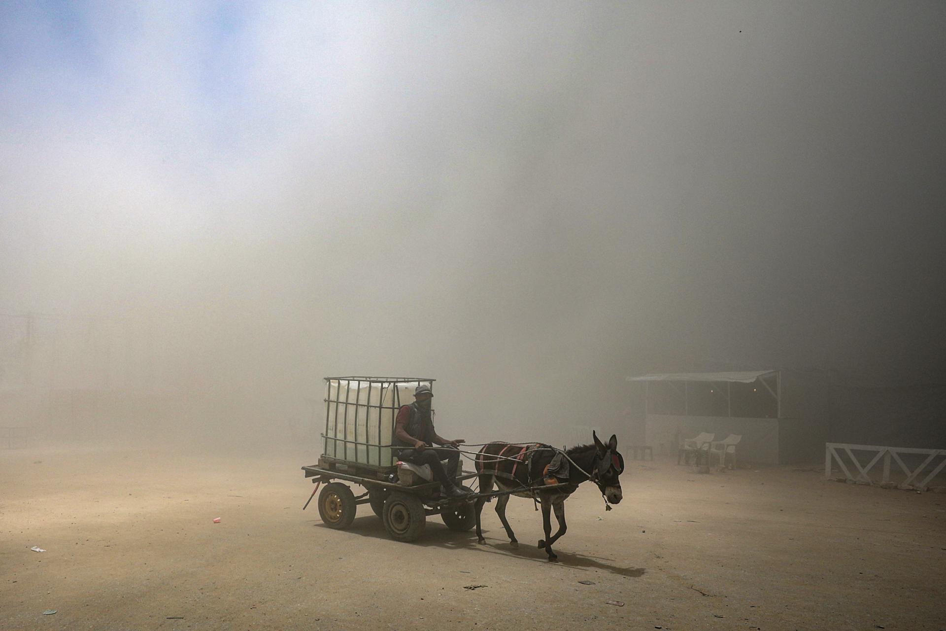 Un palestino viaja en un carro tirado por animales mientras se eleva humo tras un ataque aéreo israelí al oeste de la ciudad de Gaza, en la Franja de Gaza, el 23 de mayo de 2025. Más de 53.700 palestinos han muerto en la Franja de Gaza, según el Ministerio de Salud palestino, desde que Israel lanzó una campaña militar en la franja en respuesta a un ataque transfronterizo liderado por el grupo militante palestino Hamás el 7 de octubre de 2023, en el que murieron unos 1.200 israelíes y más de 250 fueron tomados como rehenes. EFE/EPA/MOHAMMED SABER