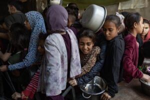 Cientos de palestinos desplazados se reúnen frente a la Cocina Solidaria Sokar en la Gaza para recibir raciones limitadas de comida, el 21 de mayo de 2025. EFE/EPA/HAITHAM IMAD