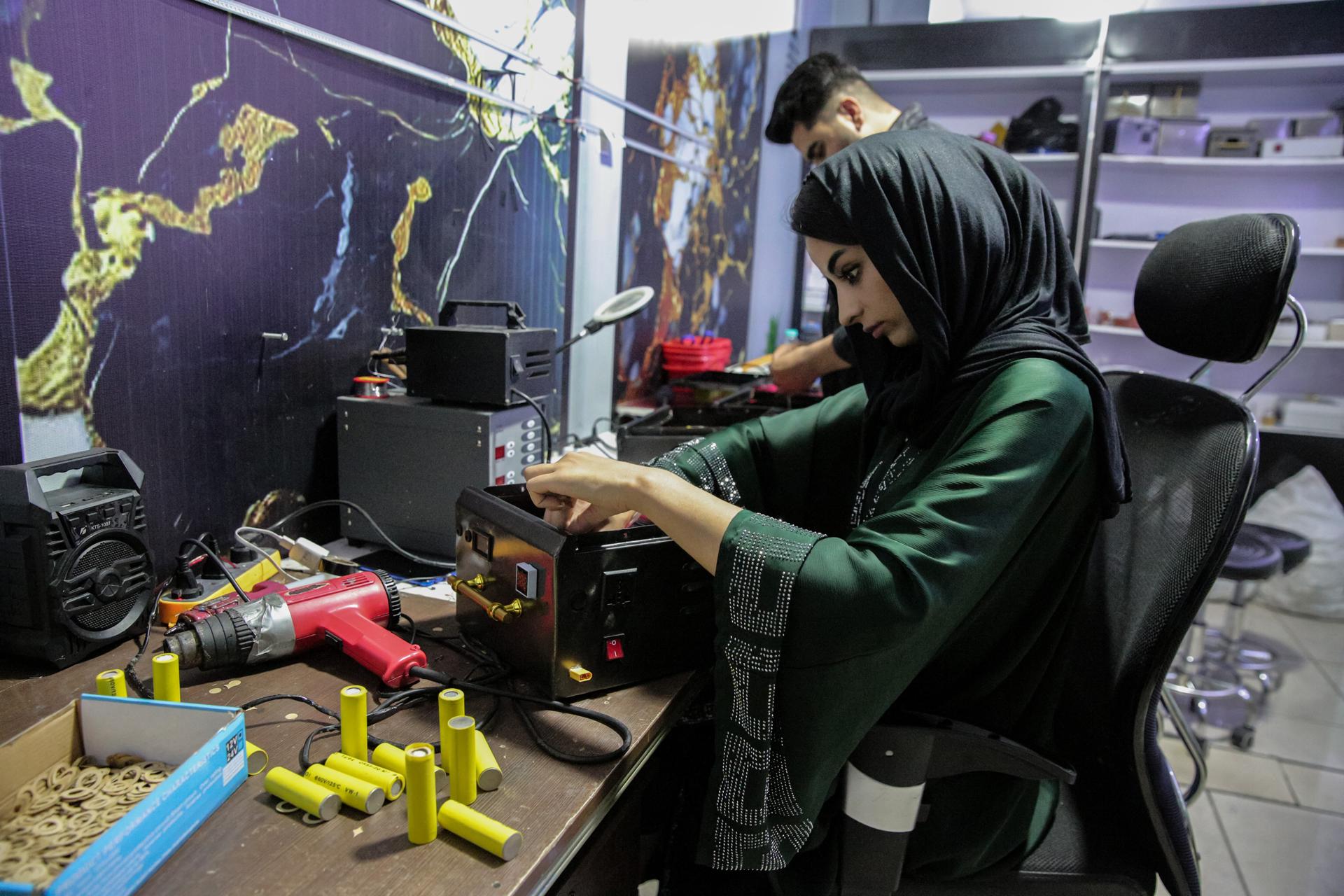 - Zahra Ali (R), una niña afgana, ensambla baterías portátiles en su taller en Kabul, Afganistán, el 30 de abril de 2025. Zahra Ali, una innovadora de 23 años en Kabul, dirige un equipo que produce baterías de litio caseras, proporcionando electricidad muy necesaria a los hogares en las regiones desatendidas de Afganistán. Cada batería, que oscila entre uno y cinco kilovatios, se fabrica utilizando piezas recicladas de coches Tesla procedentes de Dubái, con cada placa que potencialmente vale 24.000 dólares estadounidenses en el mercado comercial. El taller de Zahra produce actualmente tres baterías diarias, pero tiene dificultades para satisfacer la creciente demanda, generando entre 2.000 y 5.000 dólares mensuales, que se reinvierten en la adquisición de más materiales. Ella enfatiza el impacto de su trabajo, afirmando que "las baterías que produzco pueden alimentar equipos de producción; con este trabajo, estoy tratando de guiar a las mujeres afganas hacia la autosuficiencia". A pesar de los desafíos, Zahra aspira a inspirar a más mujeres a entrar en el campo de la tecnología y planea lanzar clases de robótica para niñas en el futuro. (Afganistán) EFE/EPA/SAMIULLAH POPAL
