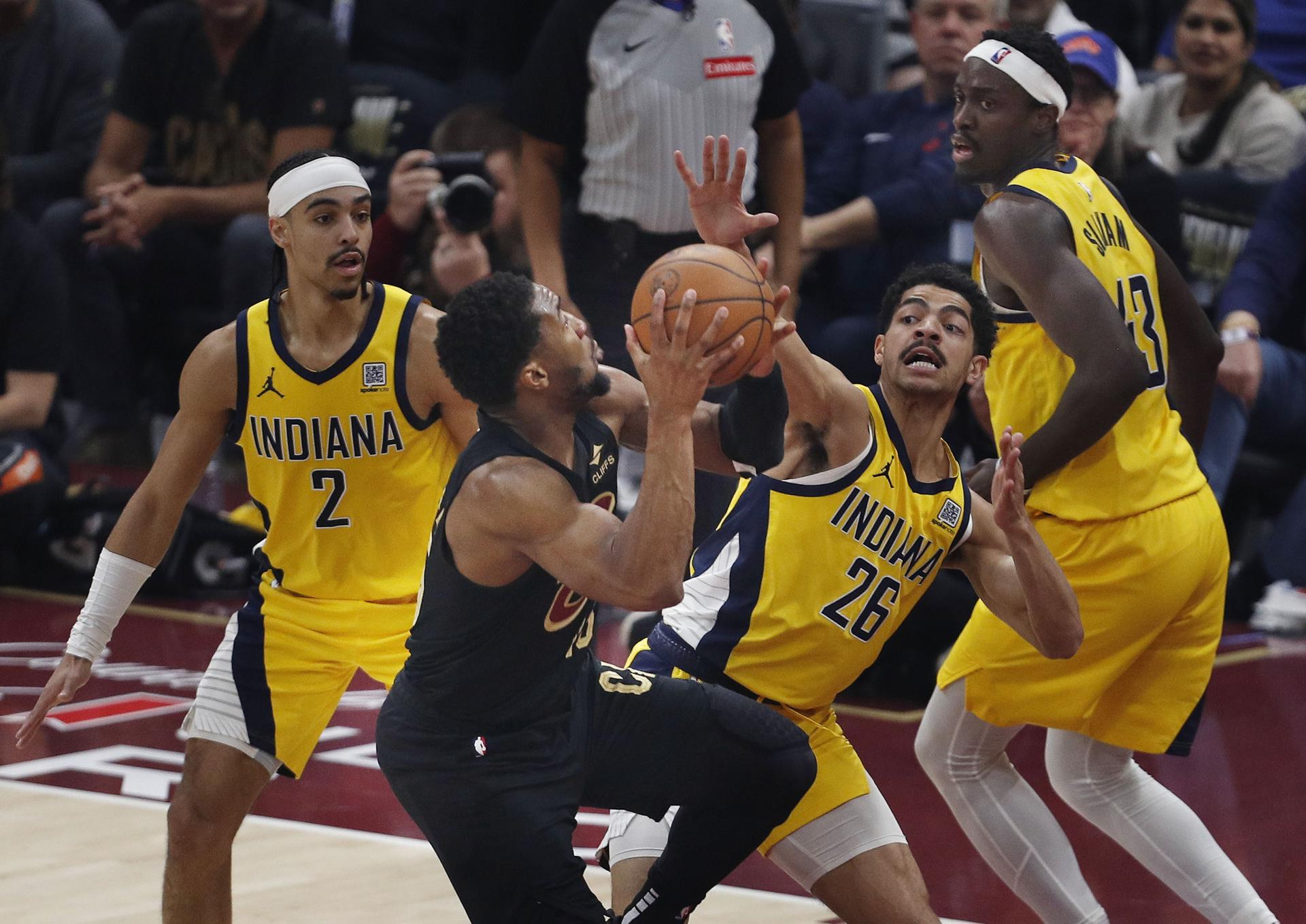 El escolta de los Cleveland Cavaliers Donovan Mitchell (2-I) trata de entrar a canasta defendido por el escolta de los Indiana Pacers Andrew Nembhard (I).EFE/EPA/DAVID MAXWELL