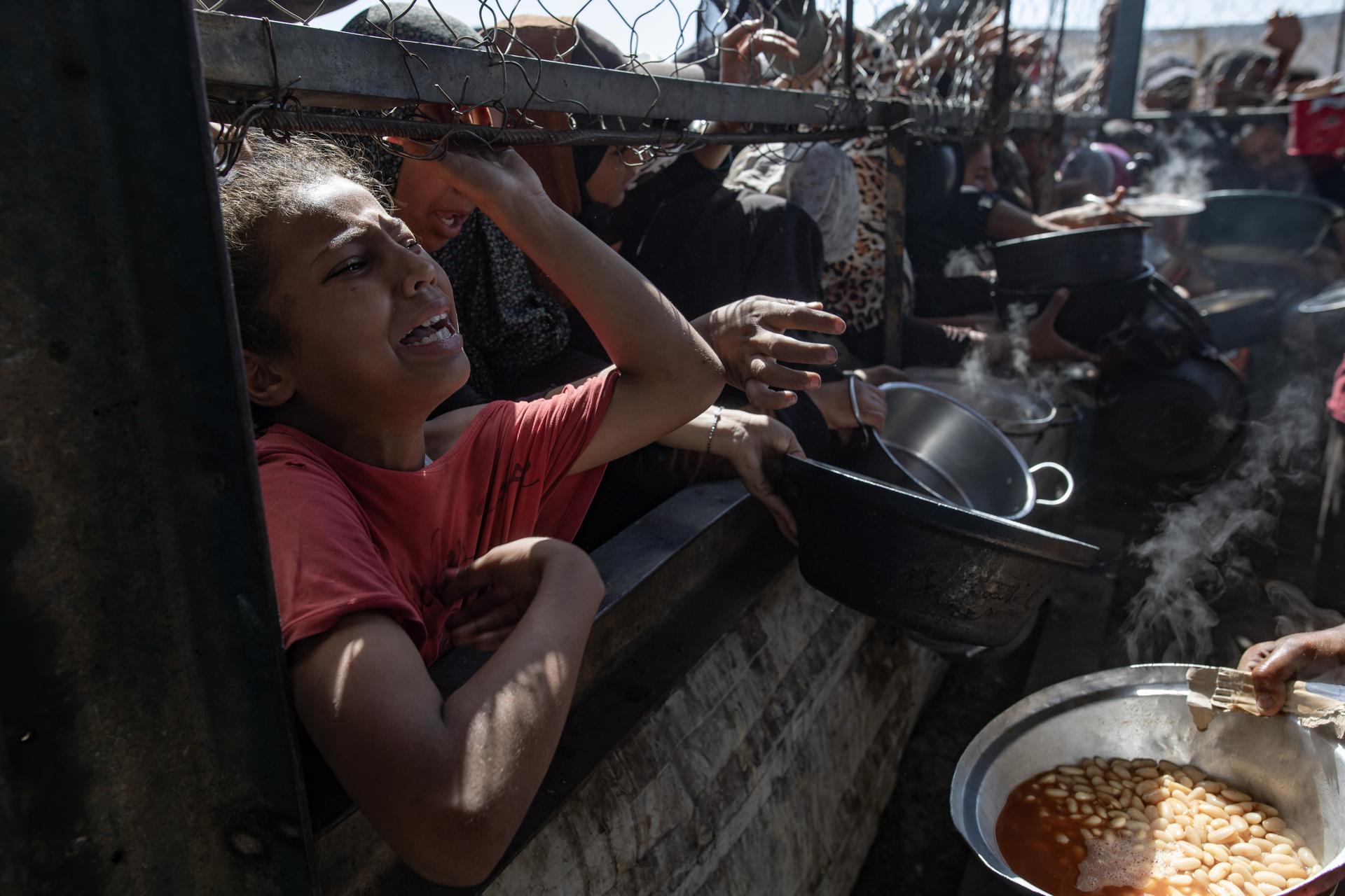 Palestinos desplazados internos se agolpan para recibir alimentos en Jan Yunis, sur de la Franja de Gaza, 30 de mayo de 2025. EFE/EPA/HAITHAM IMAD