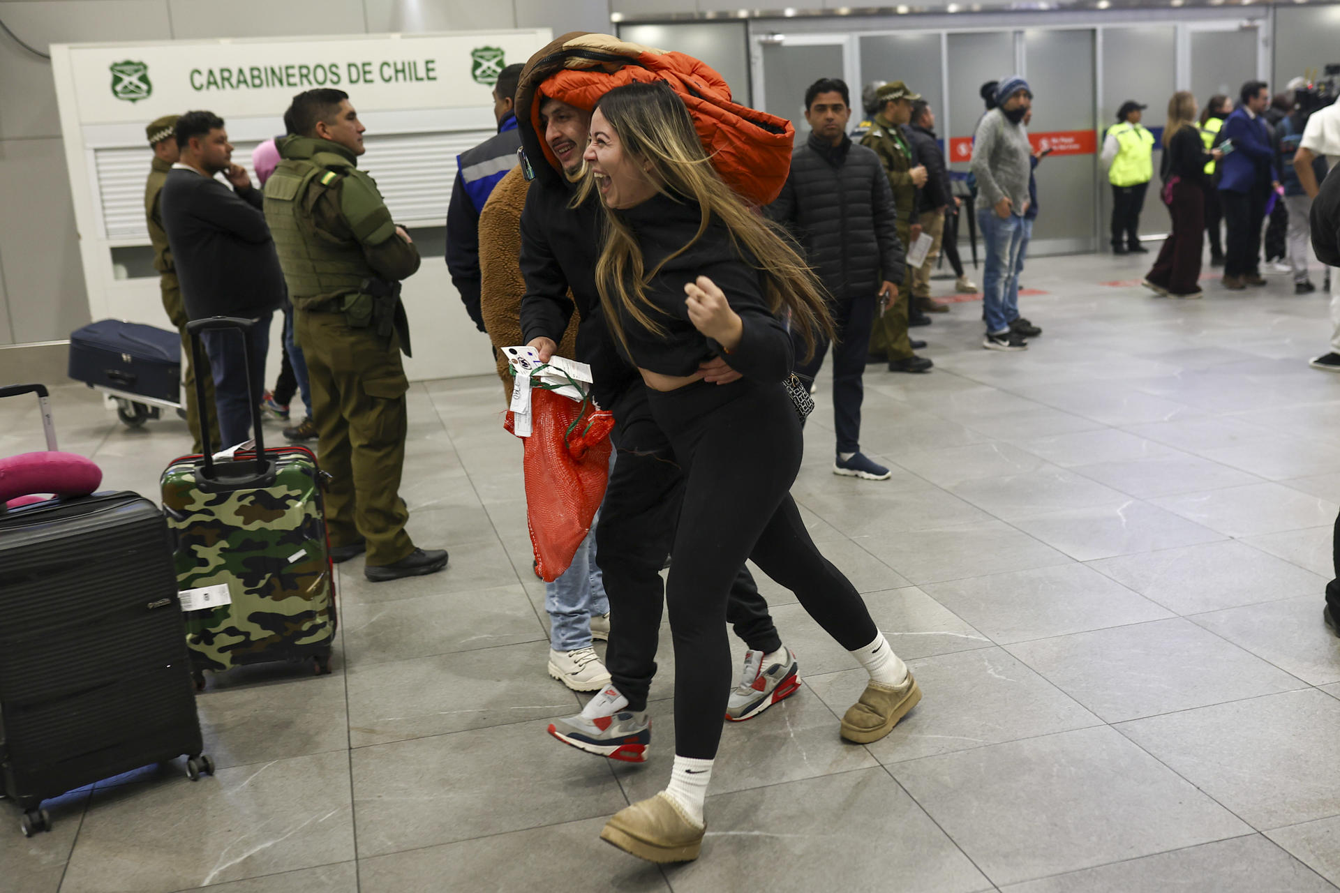 Una mujer abraza a su pareja deportada a su llegada al aeropuerto Internacional Arturo Merino Benítez en Santiago (Chile) en la madrugada de este viernes. EFE/ Rafael Arancibia