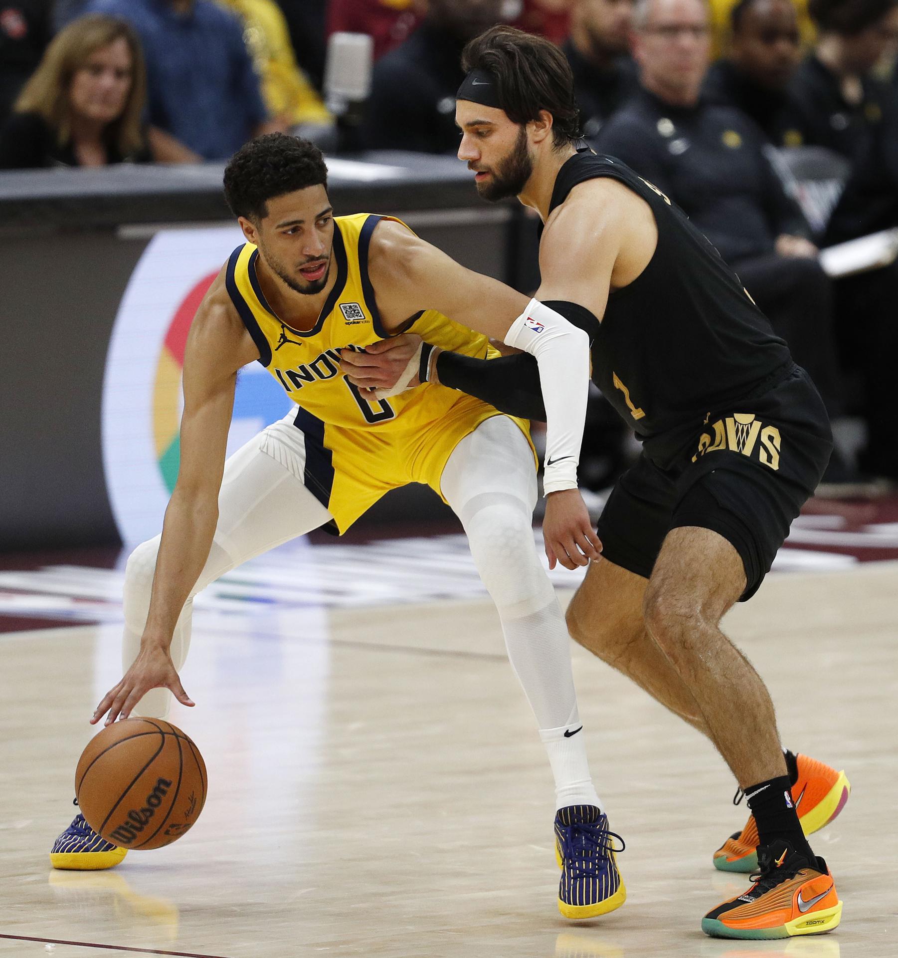 El escolta de los Indiana Pacers Tyrese Haliburton (I) protege el balón de la defensa del escolta de los Cleveland Cavaliers Max Strus (D). EFE/EPA/DAVID MAXWELL