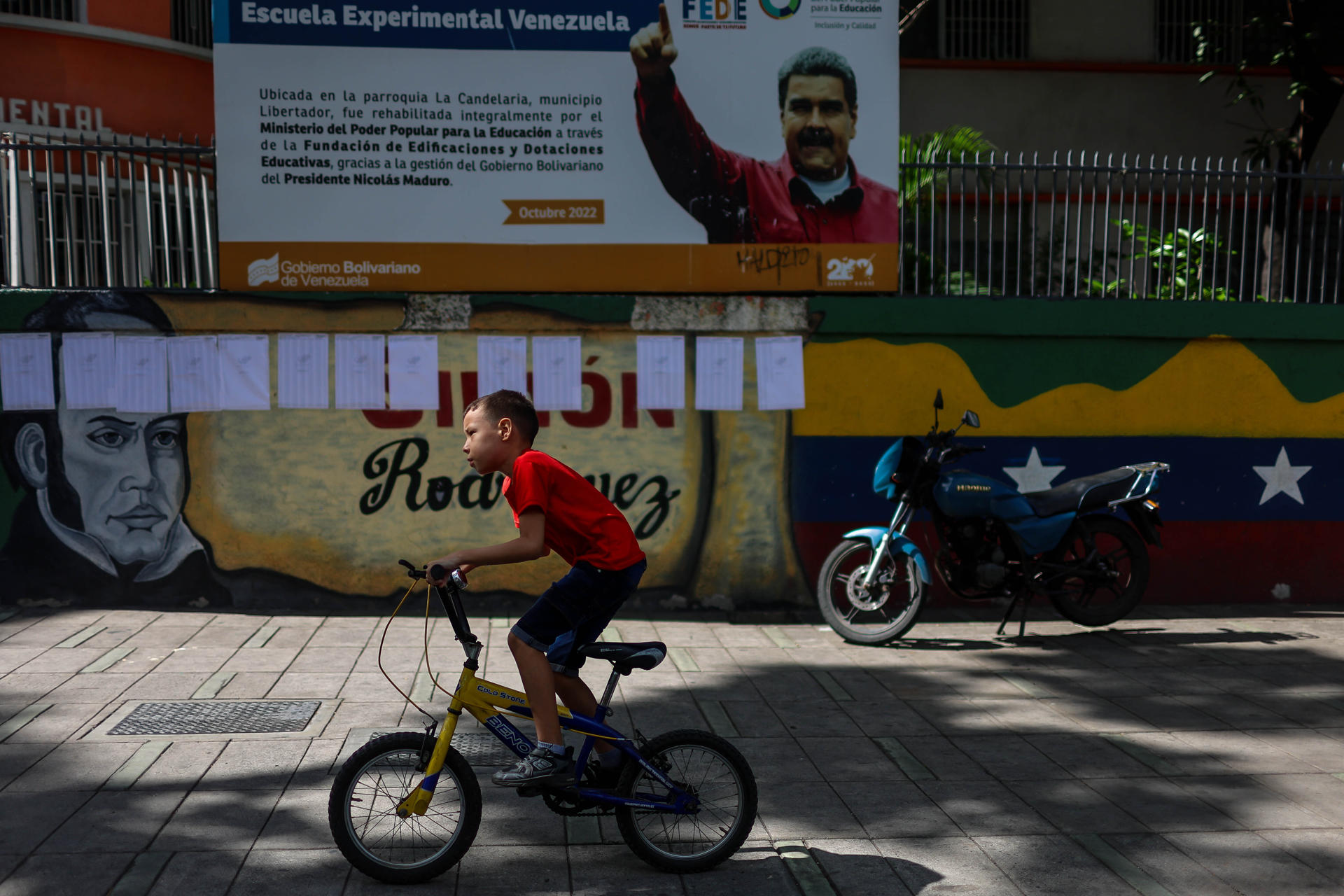 Un niño en bicicleta cruza frente a un centro de votación este domingo, en Carcas (Venezuela). EFE/ Miguel Gutierrez
