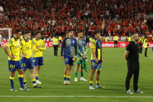 Los jugadores de la UD Las Palmas y su entrenador Diego Martínez (d) al finalizar el partido de la jornada 36 de LaLiga que Sevilla FC y UD Las Palmas disputaron este martes en el estadio Ramón Sánchez-Pizjuán. EFE/Julio Muñoz