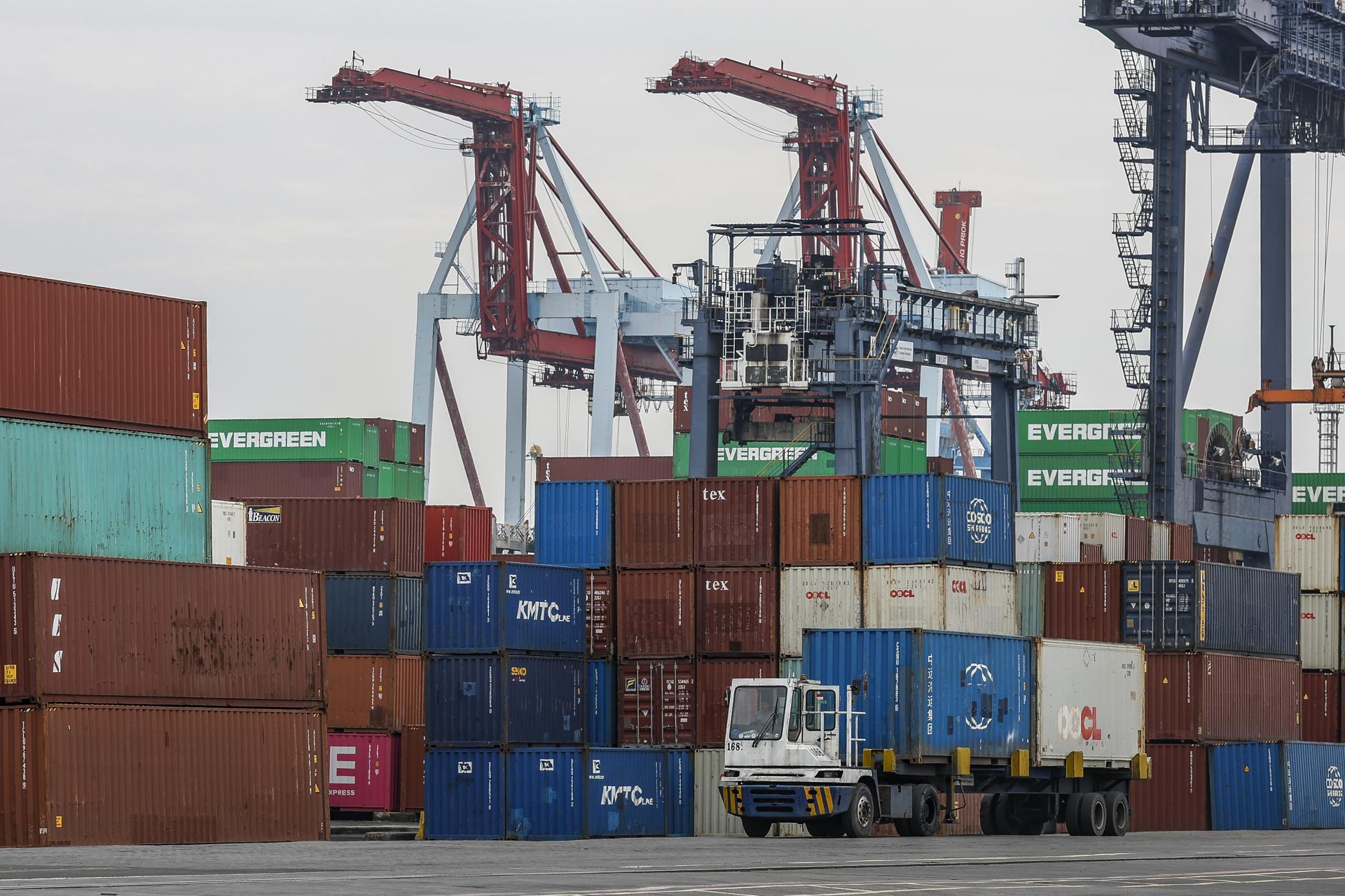 Fotografía de archivo de un camión que circula frente a pilas de contenedores en el Terminal Internacional de Contenedores de Yakarta (JICT) en el puerto de Tanjung Priok, Yakarta (Indonesia). EFE/EPA/MAST IRHAM