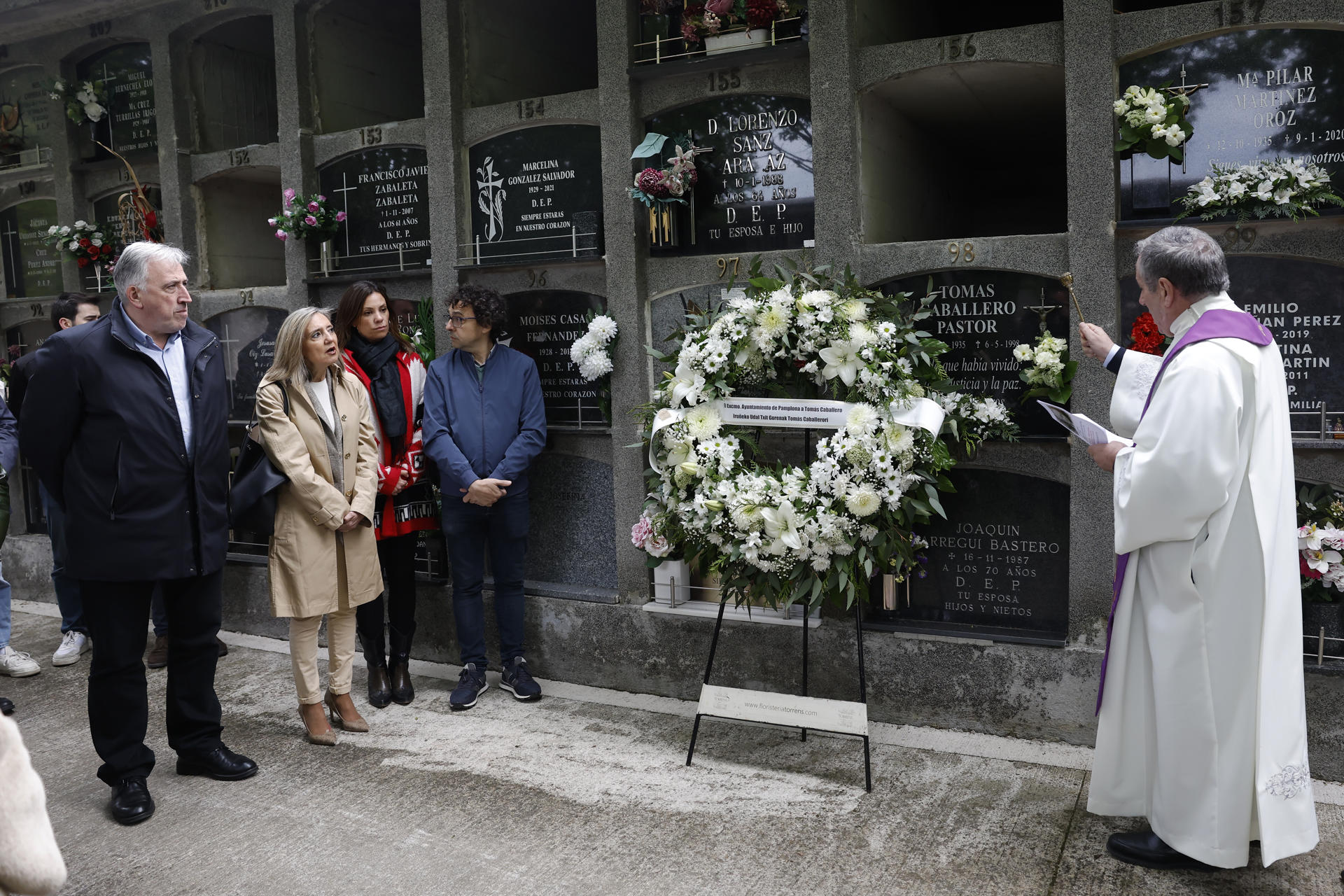 El Ayuntamiento de Pamplona, con el alcalde Joseba Asirón (i) a la cabeza y acompañado entre otros por la concejal de UPN, Cristina Ibarrola (2i), durante el homenaje este martes al concejal de UPN Tomás Caballero asesinado el 6 de mayo de 1998 por la banda terrorista ETA con la celebración en el cementerio de San José de un responso por parte del párroco de San Lorenzo, Javier Leoz, y la colocación de una corona de flores. EFE/ Jesús Diges