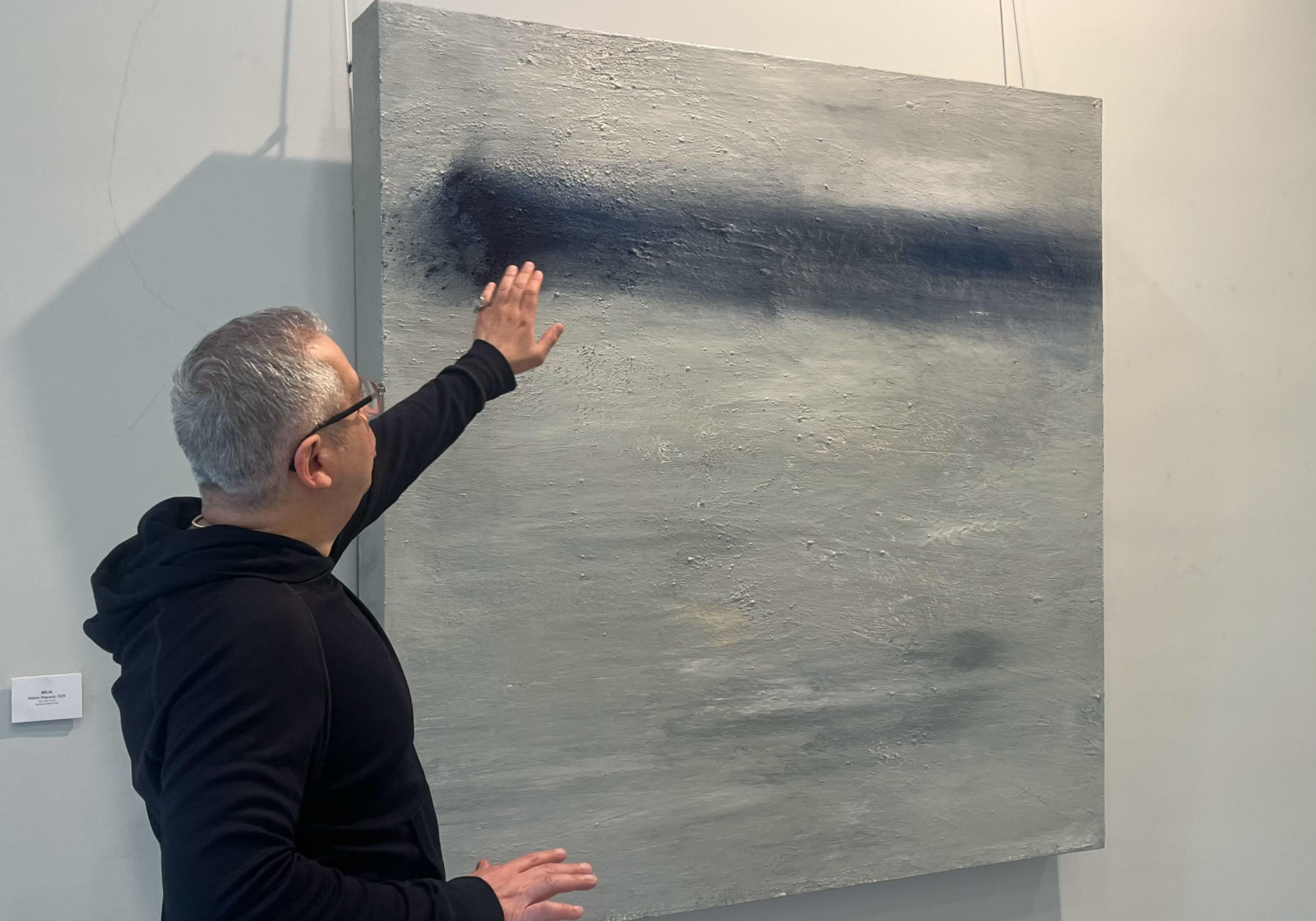 La pintura 'Delia' (2025) es una de las obras inéditas que forman parte de la nueva exhibición de Antonio Reguera (i), en París, bajo el título 'Reversible'. Este cuadro es un "paisaje espiritual" en escala de grises dedicado a una amiga del artista recientemente fallecida. Abierta al público hasta el 12 de junio, la muestra presenta una progresión cromática del frío a la calidez y continúa el estilo contemporáneo del creador, caracterizado por las texturas, los volúmenes y el paisajismo abstracto.-EFE/ Val Torres
