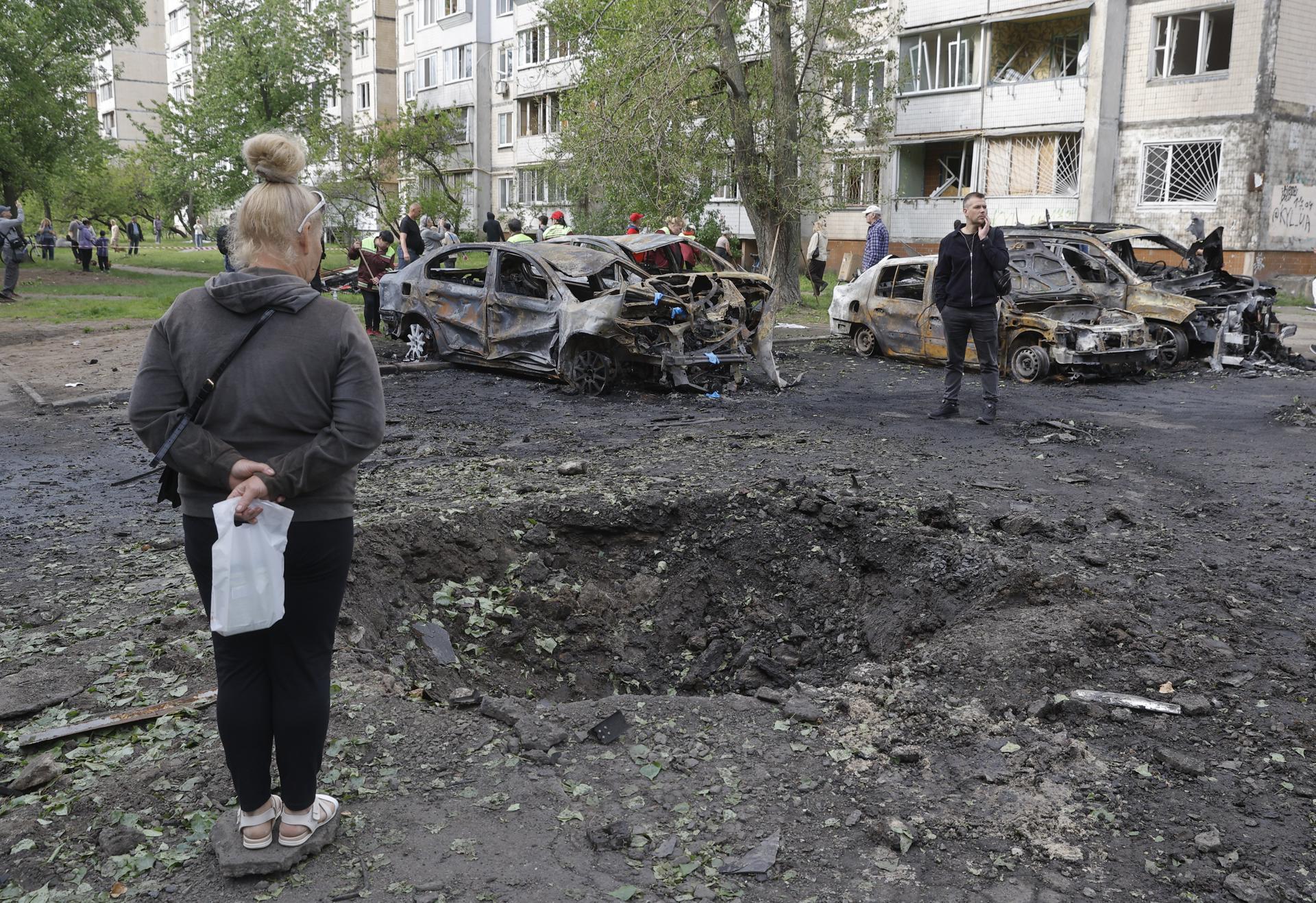 Fotografía del 4 de mayo de 2025 que muestra a residentes observando un cráter en el lugar donde se produjo un ataque ruso nocturno con drones en una zona residencial de Kiev, Ucrania. EFE/EPA/SERGEY DOLZHENKO