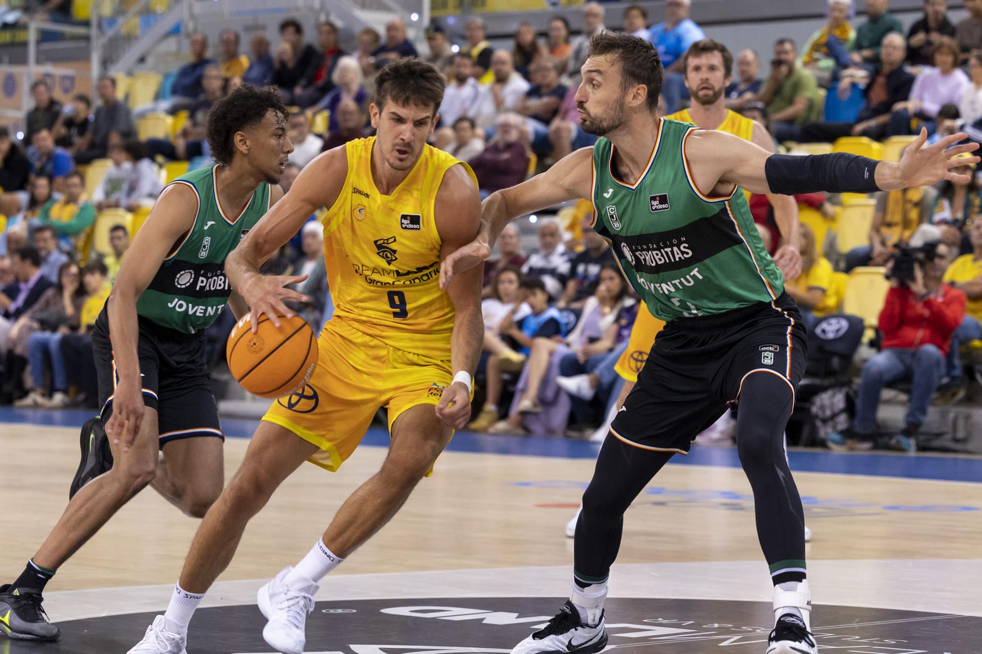 El alero argentino del Dreamland Gran Canaria Nico Brussino (c) intenta superar al alero estadounidense del Joventut Sam Dekker (d) durante el partido de Liga Endesa de baloncesto que se disputó en el Gran Canaria Arena. EFE/Quique Curbelo