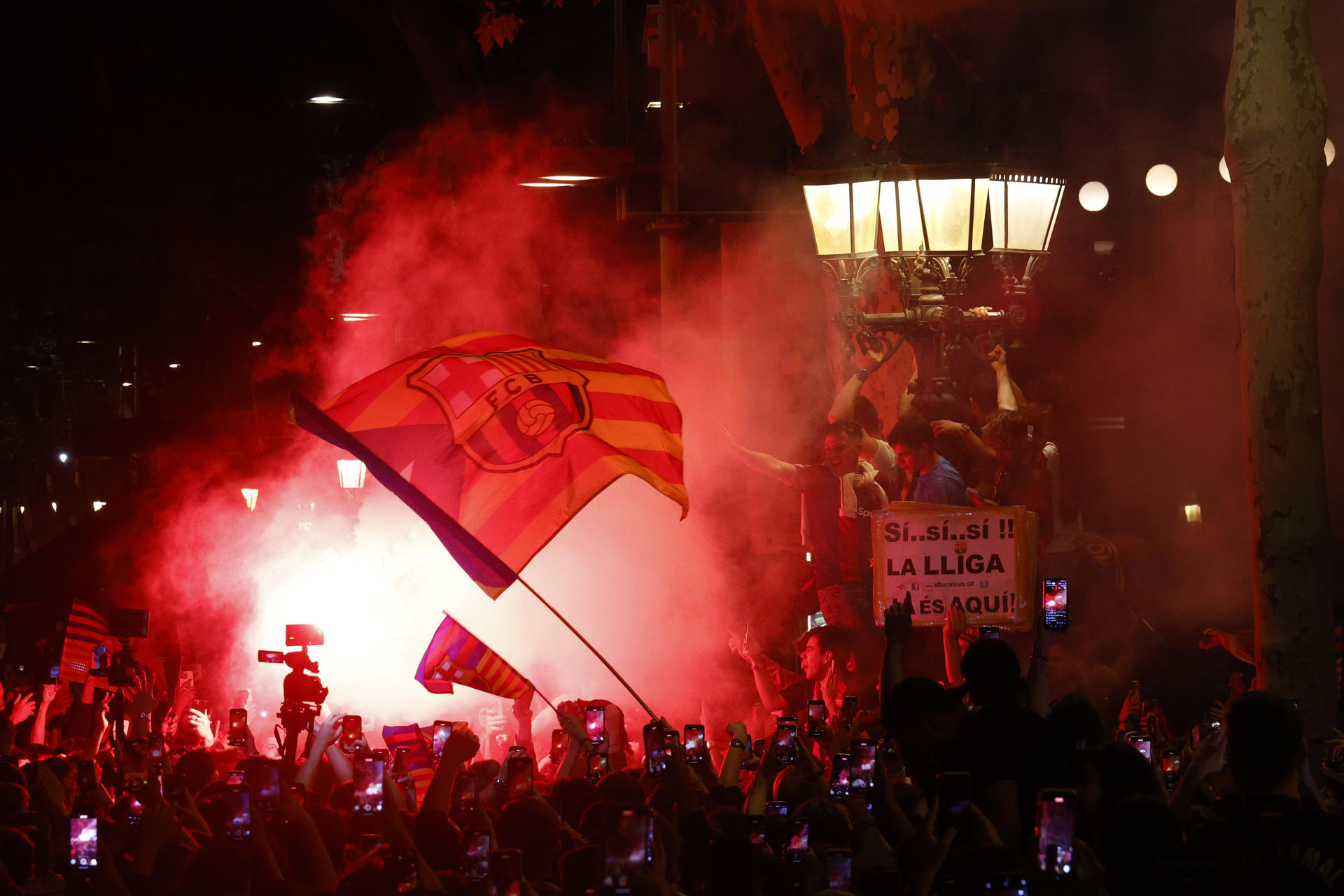 Aficionados del FC Barcelona celebran en la fuente de Canaletas el título de Liga conseguido por el equipo blaugrana tras derrotar al RCD Espanyol en el encuentro que disputaron en el RCDE Stadium, en Cornellá de Llobregat, Barcelona. EFE/Quique García.