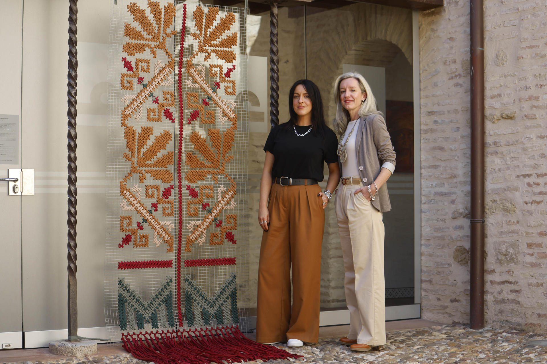 Las hermanas Almudena Castillejo (i) y Begoña Castillejo, (d) la primera artista visual y la otra sobre todo tipo de textil, han desarrollado su primera obra junta, 'Hilos de memoria, una ventana abierta al futuro de Palestina', una instalación que acoge la sede de Córdoba de Casa Árabe que une a través el bordado palestino y el flecado cordobés la cultura de los dos pueblos.. EFE/Salas