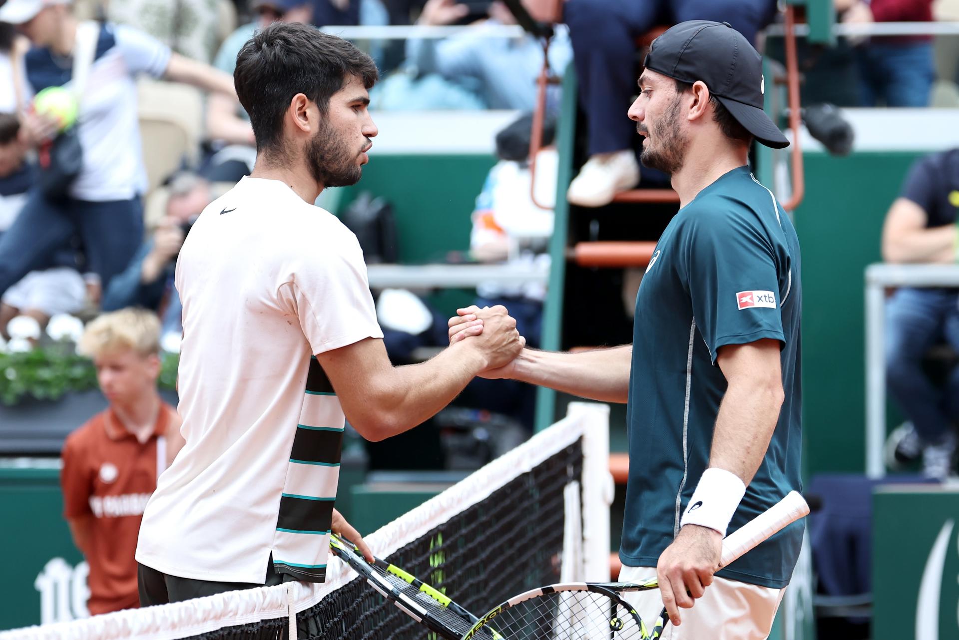 Carlos Alcaraz (I) de España es felicitado en la red por Giulio Zeppieri de Italia después de ganar su partido de 1ª ronda en Roland Garros. EFE/EPA/CHRISTOPHE PETIT TESSON
