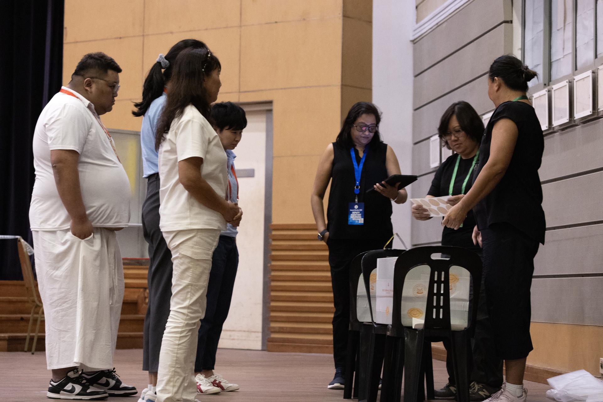 Un grupo de oficiales sella las urnas en un centro de votación en Singapur el 3 de mayo de 2025. EFE/EPA/HOW HWEE YOUNG