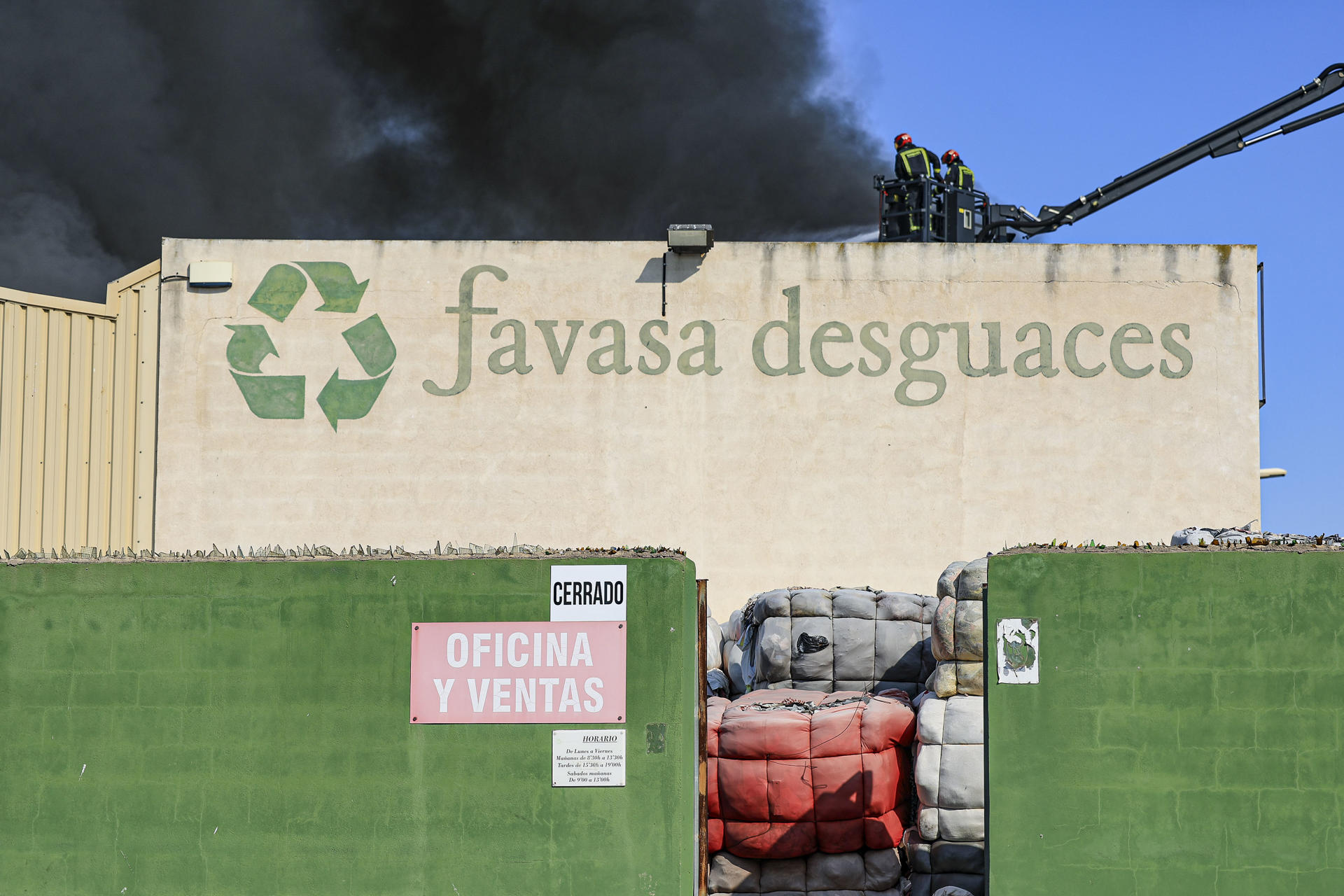 Varios medios aéreos y dotaciones terrestres de bomberos trabajan en la extinción de un incendio en una nave industrial de residuos textiles en la localidad castellonense de Almassora, que ha obligado a desalojar el polígono. EFE/Andreu Esteban