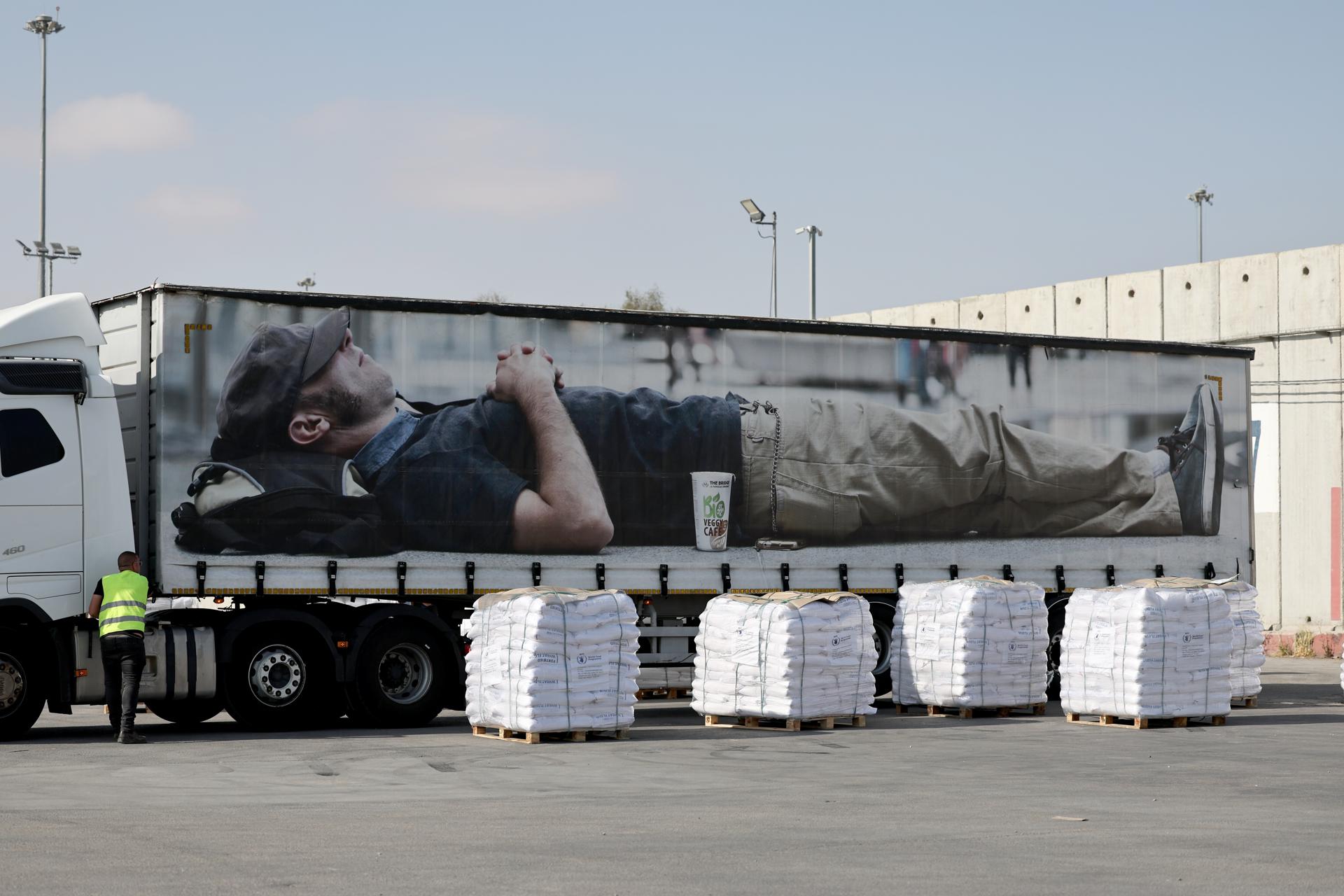 Palés de alimentos junto a camiones esperando para entrar en la Franja de Gaza en el cruce de Kerem Shalom, en el sur de Israel, 22 de mayo de 2025. Según la ONU, medio millón de personas, o una de cada cinco personas en la Franja, se enfrentan al hambre, mientras que toda la población de la Franja de Gaza sigue enfrentándose a un riesgo crítico de hambruna tras 19 meses de conflicto, desplazamiento masivo y severas restricciones a la ayuda humanitaria. EFE/EPA/ATEF SAFADI