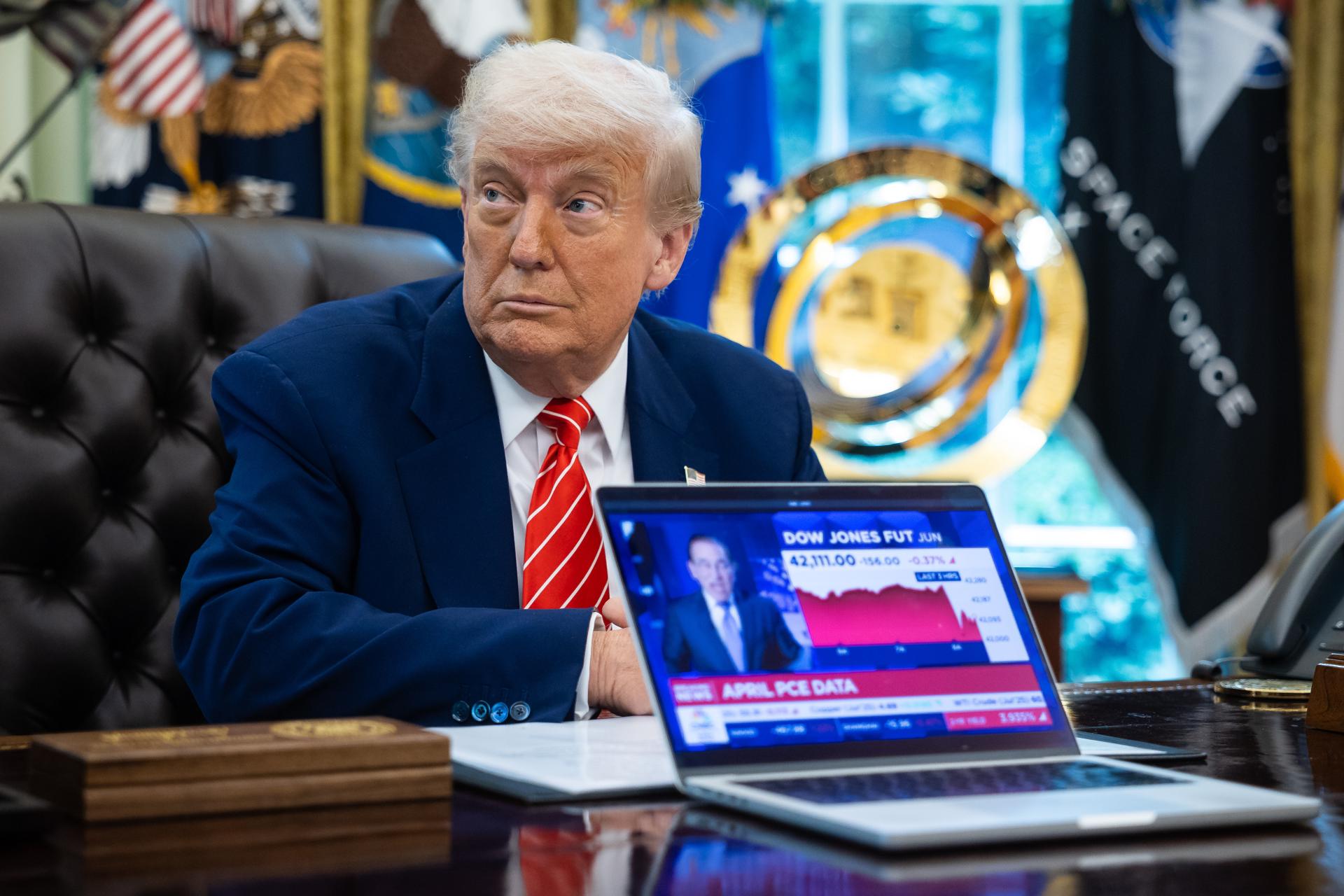 El presidente de EE. UU. Donald Trump sentado cerca de un ordenador reproduciendo un reportaje sobre el mercado de valores durante una conferencia de prensa en la Oficina Oval de la Casa Blanca en Washington, DC, EE. UU., 30 de mayo de 2025. EFE/FRANCIS CHUNG