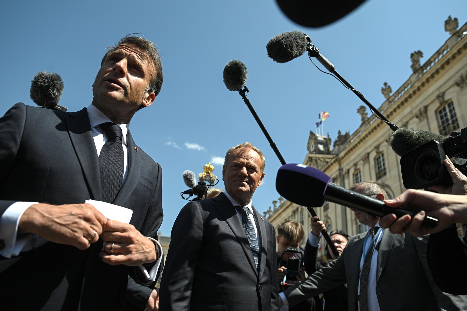 El presidente francés Emmanuel Macron (I) y el primer ministro polaco Donald Tusk (C) hablan con los medios de comunicación cuando llegan a la plaza Stanislas de Nancy, Francia, el 09 de mayo de 2025. El presidente francés Macron y el primer ministro polaco Tusk se reúnen en Nancy como parte de una cumbre para firmar un tratado de amistad y cooperación reforzada entre Francia y Polonia. (Francia, Polonia) EFE/EPA/MARCIN OBARA POLONIA FUERA
