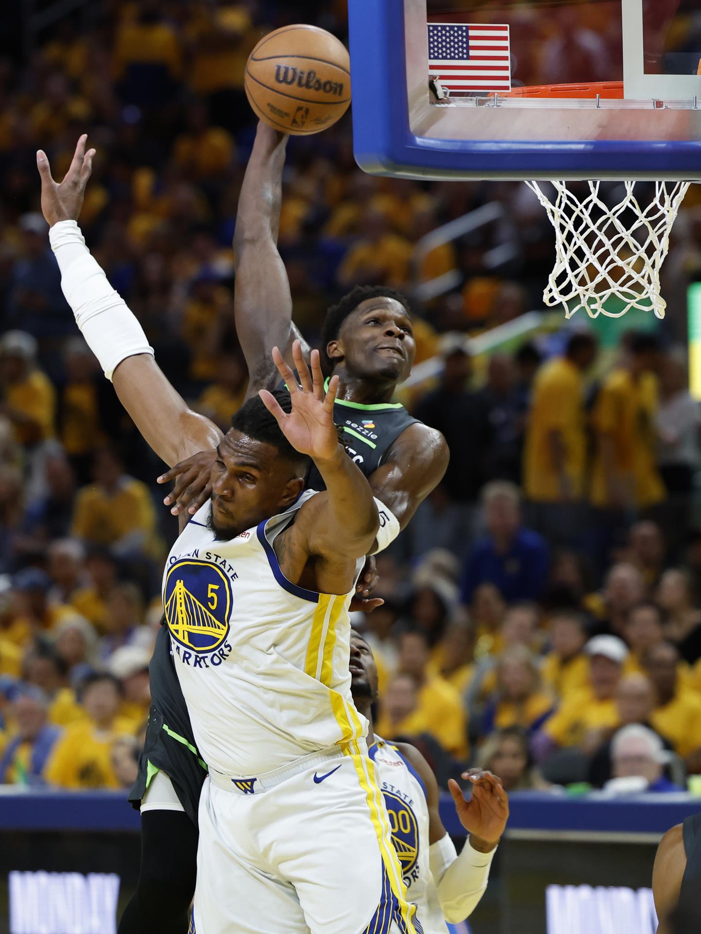 Anthony Edwards (atrás) de los Minnesota Timberwolves va a la cesta con la marca de Kevon Looney (delante) de los Golden State Warriors. EFE/JOHN G. MABANGLO