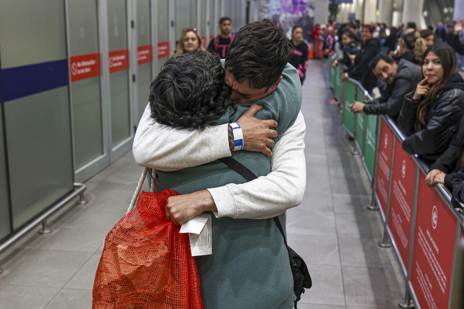 Un hombre deportado abraza a una familiar a su llegada al aeropuerto Internacional Arturo Merino Benítez en Santiago (Chile) en la madrugada de este viernes. EFE/ Rafael Arancibia