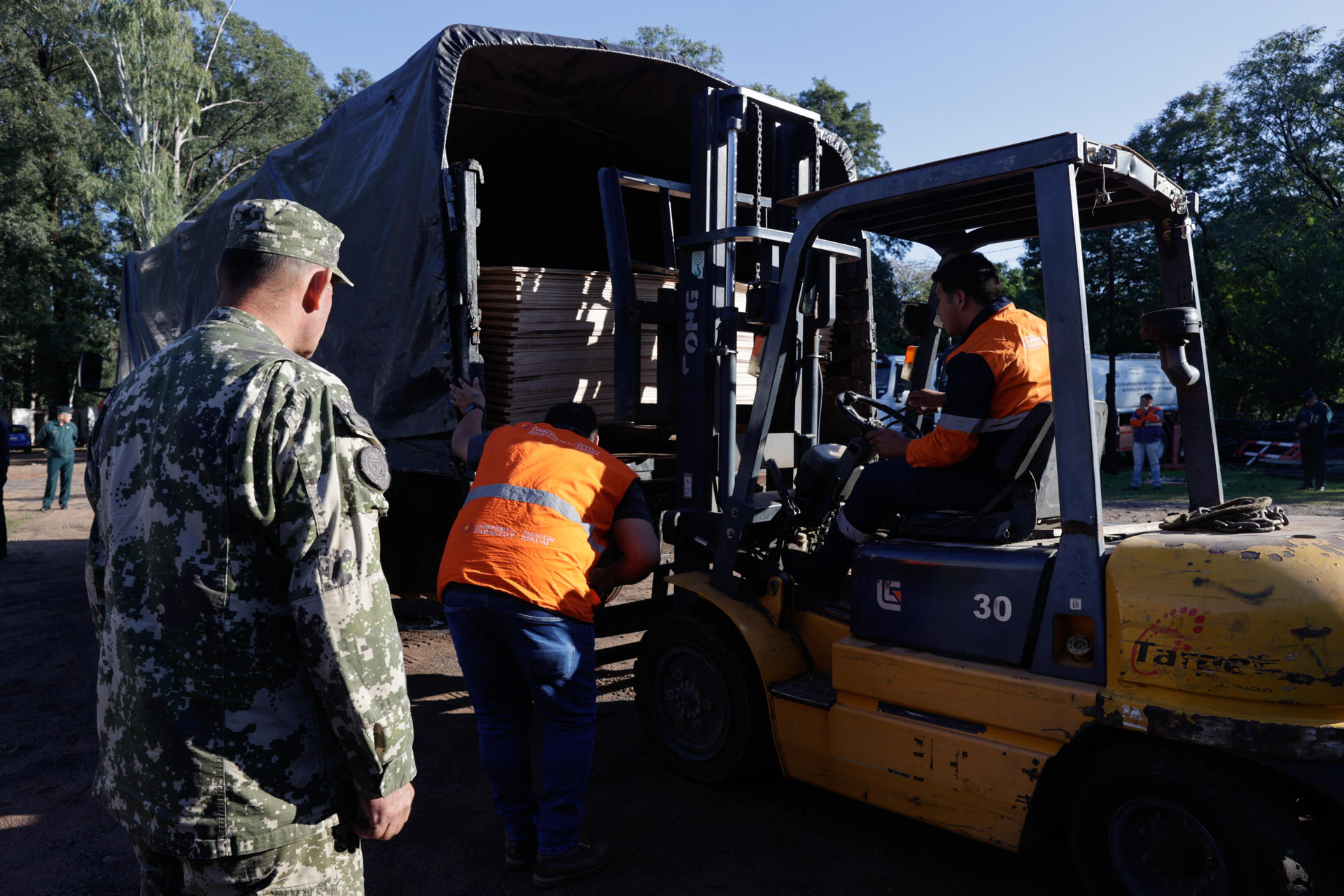 Integrantes de la Secretaría de Emergencia Nacional de Paraguay abastecen camiones del ejército paraguayo con insumos para los afectados por un temporal en Itaúa, este lunes en el Comando General del Ejército Paraguayo en Asunción (Paraguay).EFE/ Juan Pablo Pino