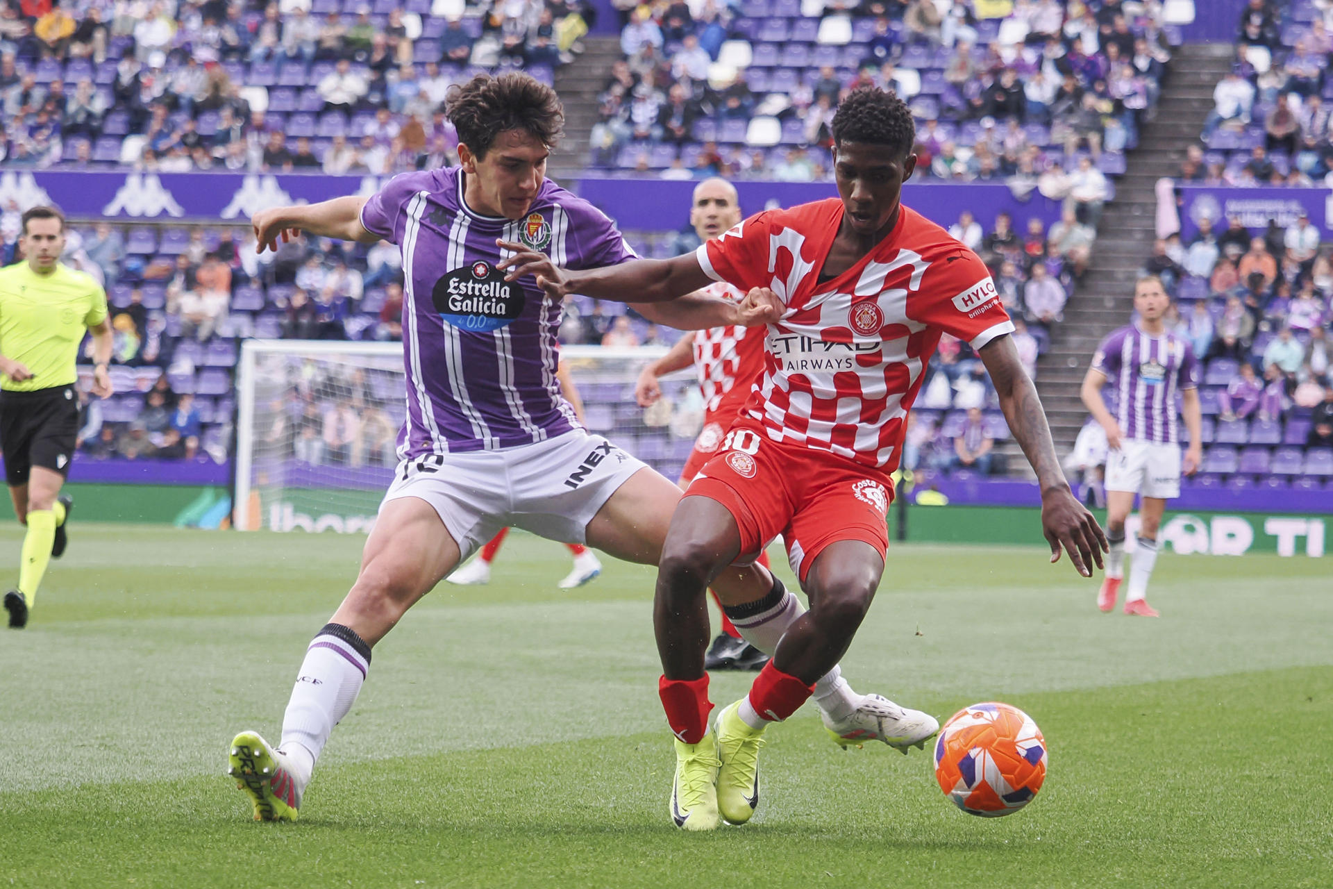 El delantero colombiano del Girona Yáser Asprilla (d) controla el balón ante el centrocampista del Valladolid Mario Martín (i) durante el partido de LaLiga entre el Real Valladolid y el Girona, este martes en el estadio José Zorrilla. EFE/R. GARCIA.