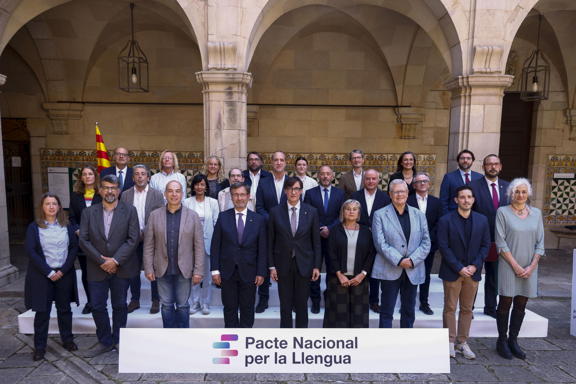 El presidente de la Generalitat, Salvador Illa (c), posa junto a los firmantes del acuerdo del Pacto Nacional por la Lengua que se ha formalizado este martes, tras el consenso alcanzado por Govern, ERC, Comuns, sindicatos, patronales y entidades, aunque sin el apoyo de Junts y la CUP. EFE/Quique García