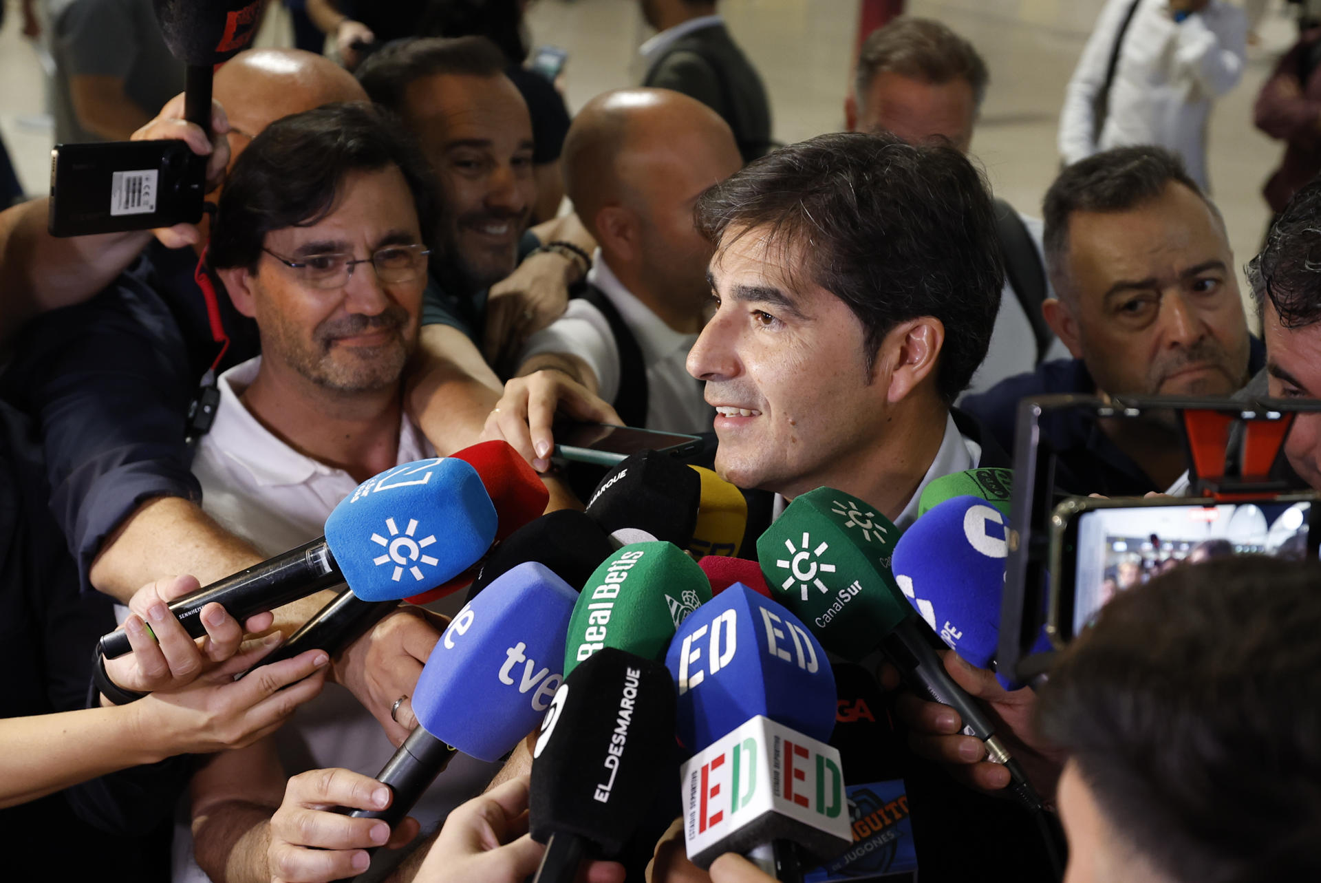 El presidente del Betis, Ángel Haro, en declaraciones este lunes a los medios en la terminal comercial del aeropuerto de Sevilla momentos antes de partir para la ciudad polaca de Breslavia donde se jugará la final de la Liga Conferencia ante el Chelsea inglés el próximo jueves. EFE/Julio Muñoz