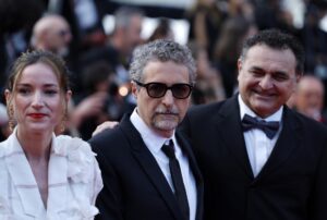 El director brasileño Kleber Mendonça Filho (c) posa en la alfombra roja junto a la productora Emilie Lesclaux (i) y un invitado este sábado, antes de la ceremonia de clausura y entrega de premios del 78º Festival de Cine de Cannes. EFE/EPA/GUILLAUME HORCAJUELO