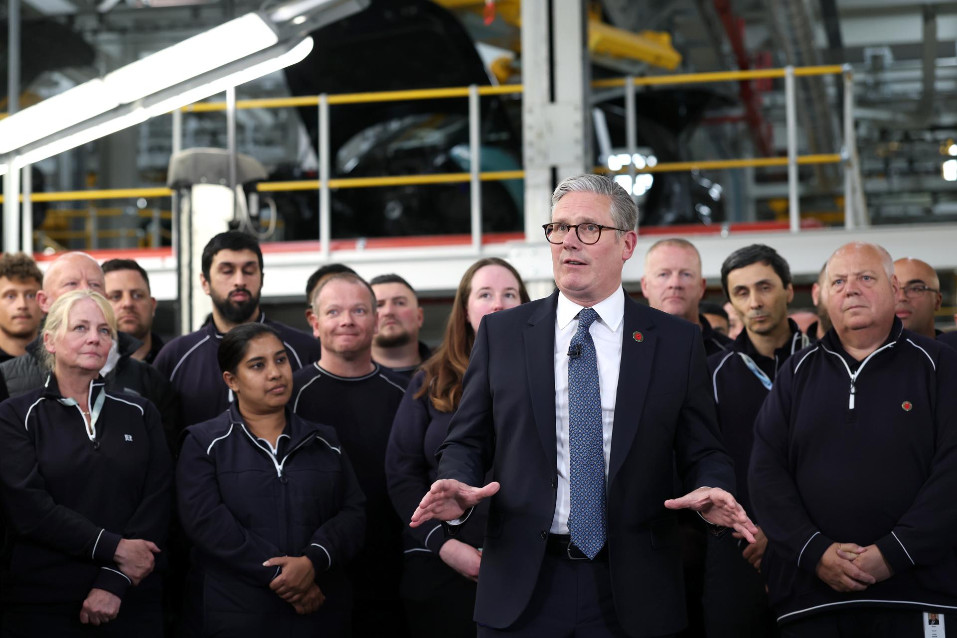 El primer ministro británico, Keir Starmer (centro), habla con los medios tras una conversación telefónica con el presidente estadounidense, Donald Trump, en una planta de fabricación de automóviles de Jaguar Land Rover en West Midlands, Reino Unido, el pasado 8 de mayo. EFE/EPA/DARREN STAPLES / POOL
