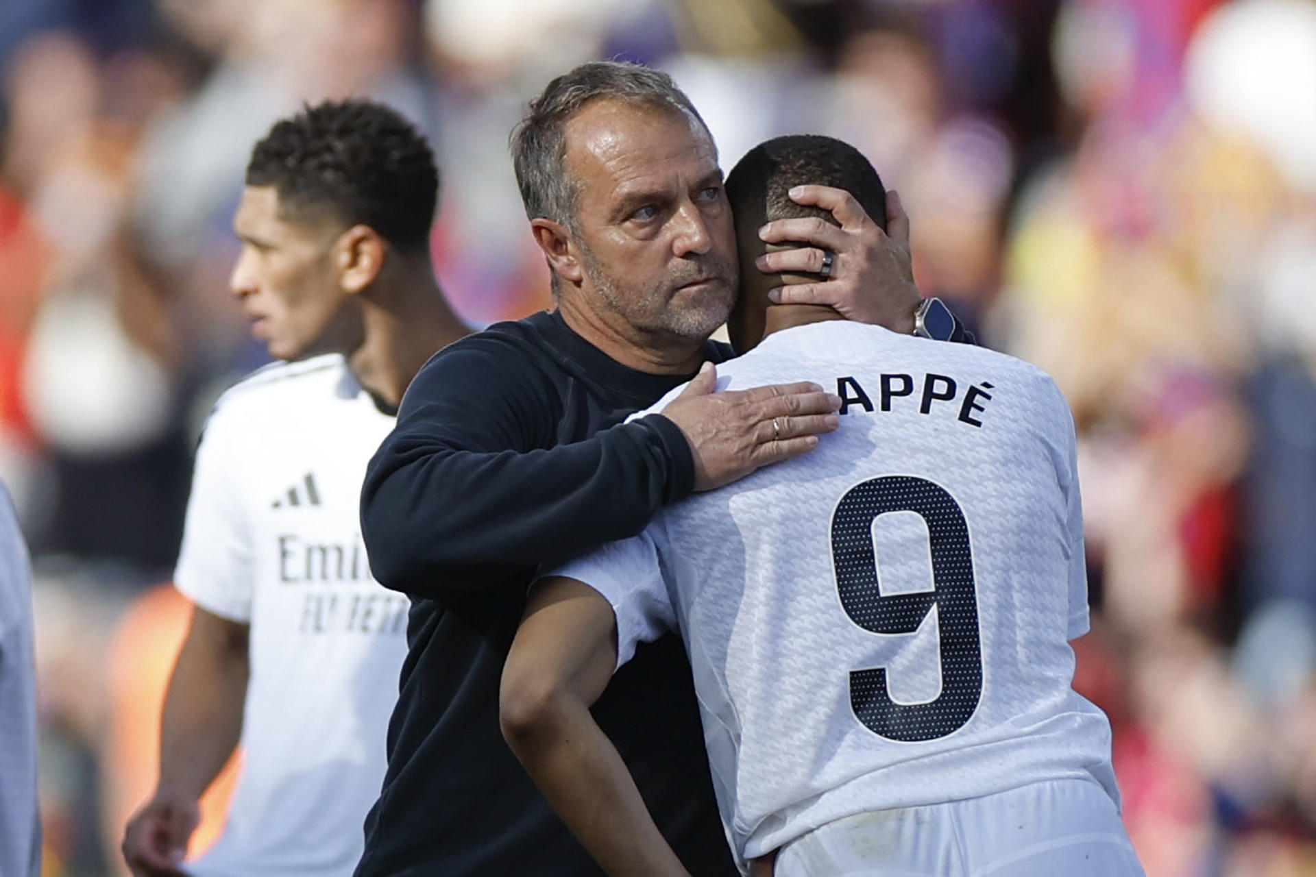 El técnico alemán del FC Barcelona, Hansi Flick, saluda al delantero francés del Real Madrid, Kylian Mbappé, a la finalización del partido de la jornada 35 de LaLiga EA Sports entre el Barcelona y el Real Madrid, este domingo en el Estadi Olímpic Lluís Companys. EFE / Alberto Estevez.